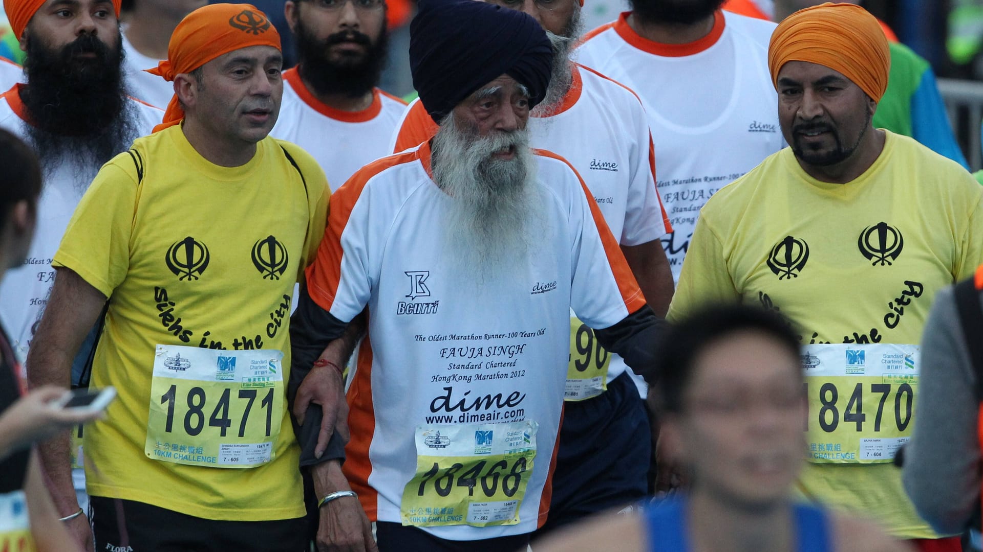 Fauja Singh (M.) beim Marathin in Hongkong, an dem er 2012 teilnahm.