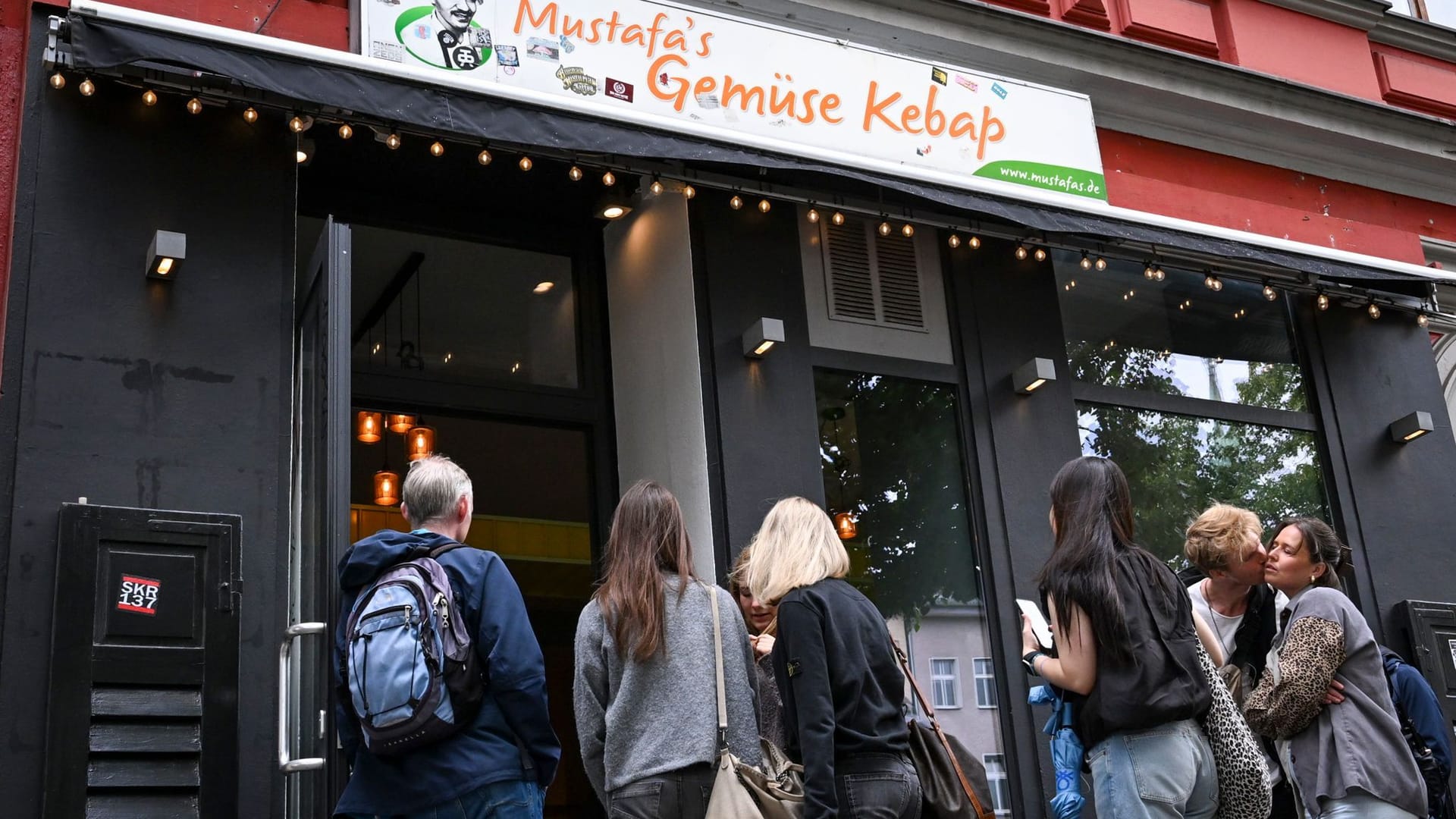 Kunden stehen vor dem neuen "Mustafa's Gemüse Kebab" am Mittwoch: Ein Schild weist Touristen hierhin den Weg.