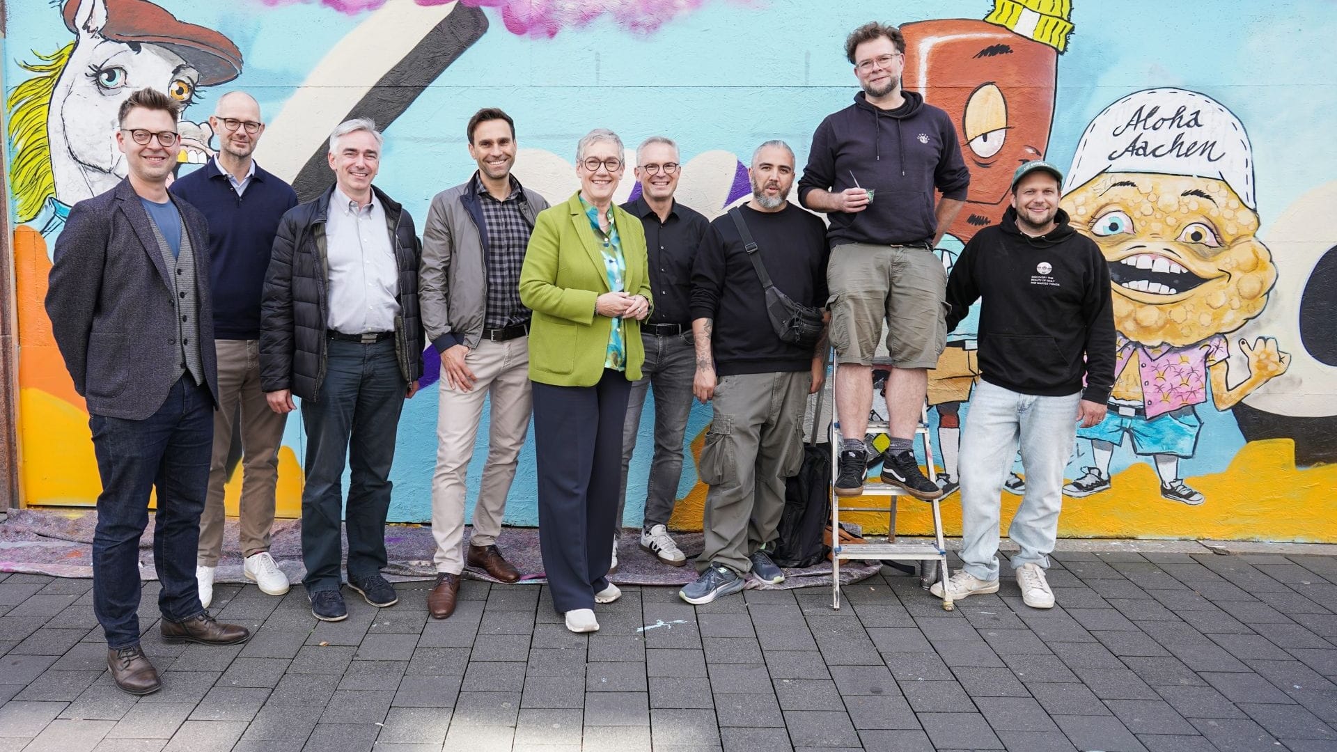 Beteiligt am Projekt: Kai Hennes (Citymanagement), Dr. Kevin Meyer (Midstad), Dirk Kuckelkorn, Gregory Hedderich (Isa Adalbertstraße), Oberbürgermeisterin Sibylle Keupen, Guido Kuckelkorn (ISA Adalbertstraße), die Künstler Michael Gerst, Alex Elsen und Paul Sous (v.l.n.r.)
