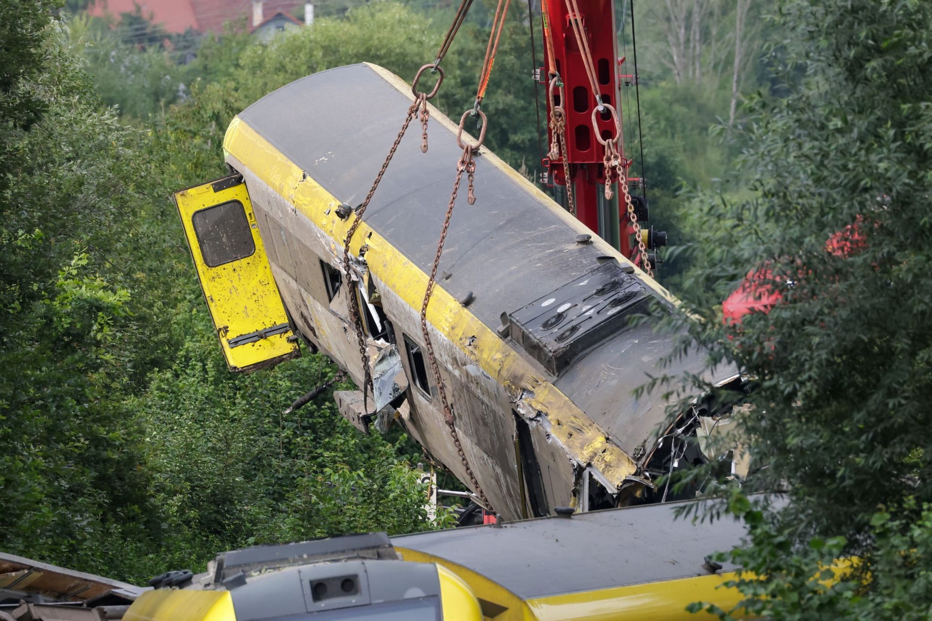 Mit einem Kran wird an der Unfallstelle, an der ein Regionalzug entgleist ist, ein Waggon angehoben: Ein Experte sieht die Gefahr weiterer Erdrutsche.