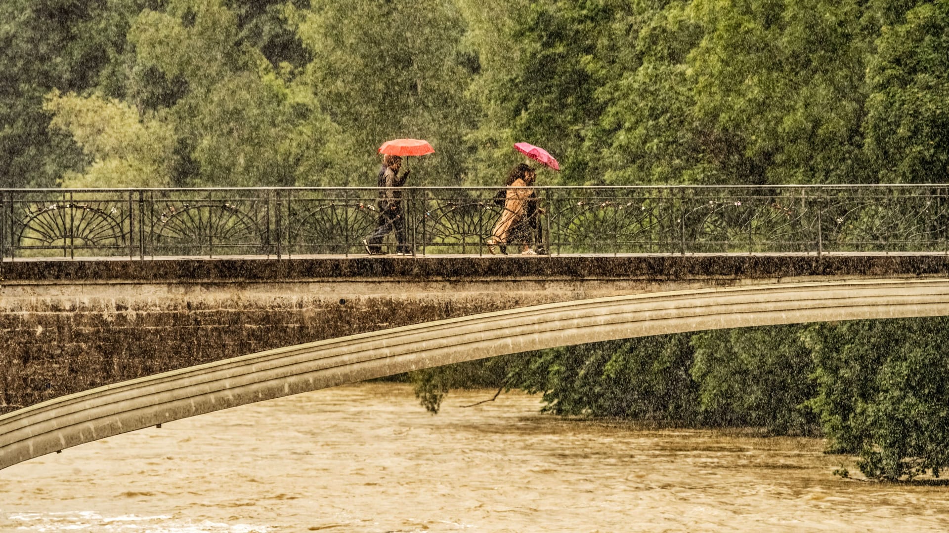 Passanten überqueren den Kabelsteg bei strömendem Regen: Auch am Donnerstag ist keine Besserung der Wetterlage in Sicht.