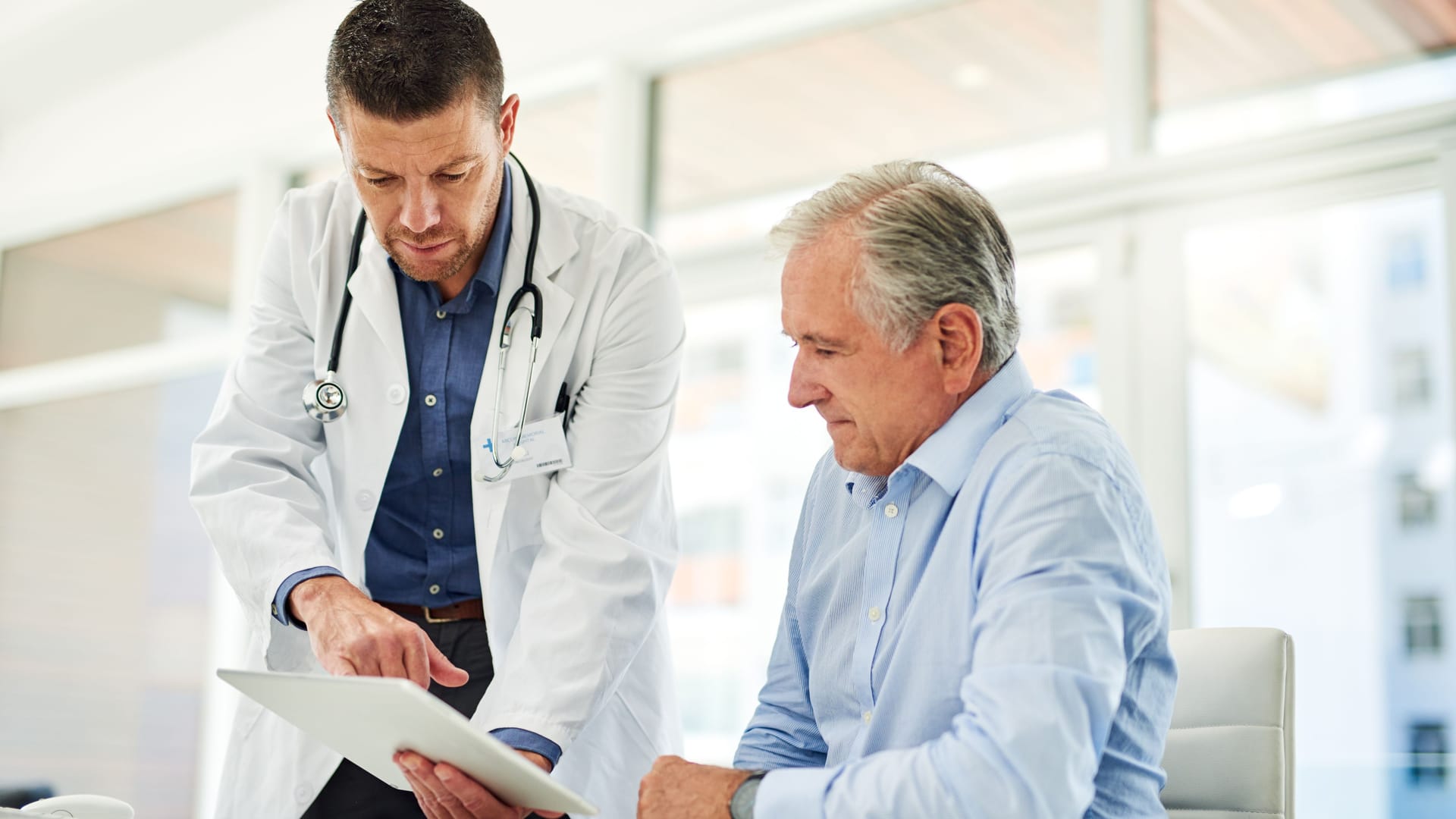 Ein Arzt erklärt einem Patienten einen Laborbefund.