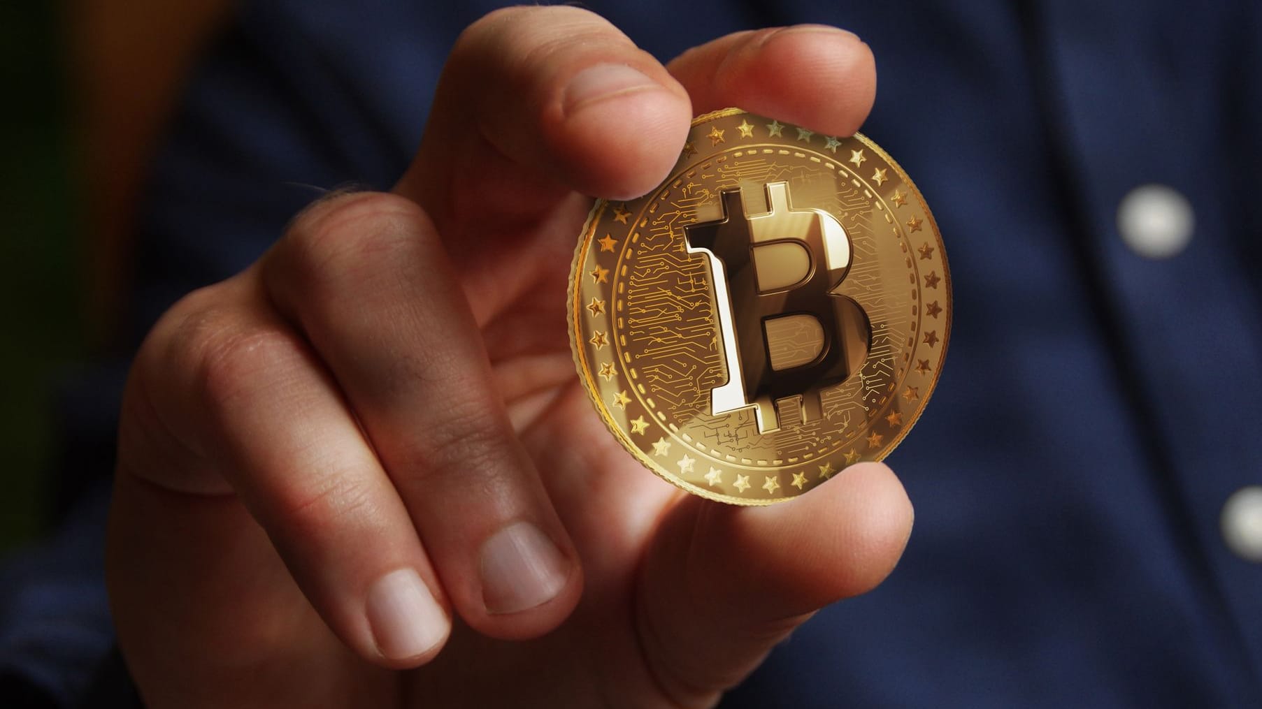Hand hält einen Bitcoin Hand hält einen Bitcoin