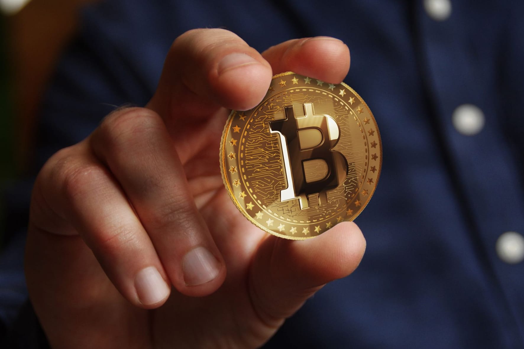 Hand hält einen Bitcoin