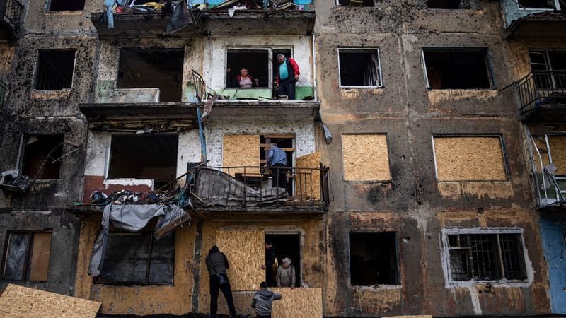 Anwohner schließen die Fenster eines Wohnhauses mit Sperrholz nach russischem Beschuss in Dobropillja in der Region Donezk in der Ostukraine.