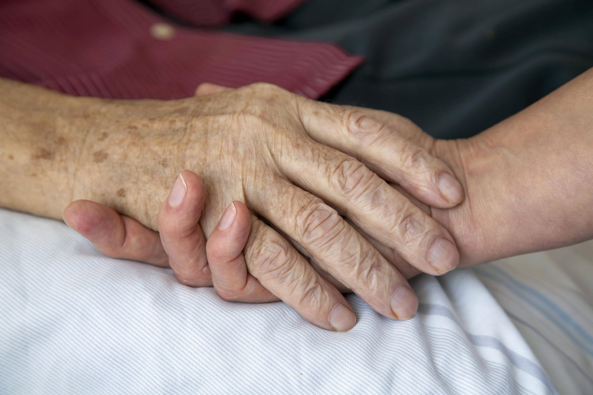 Pflegerin hält Hand eines sterbenden Mannes (Symbolfoto): Ein Berliner Arzt soll zahlreiche Menschen auf dem Gewissen haben.