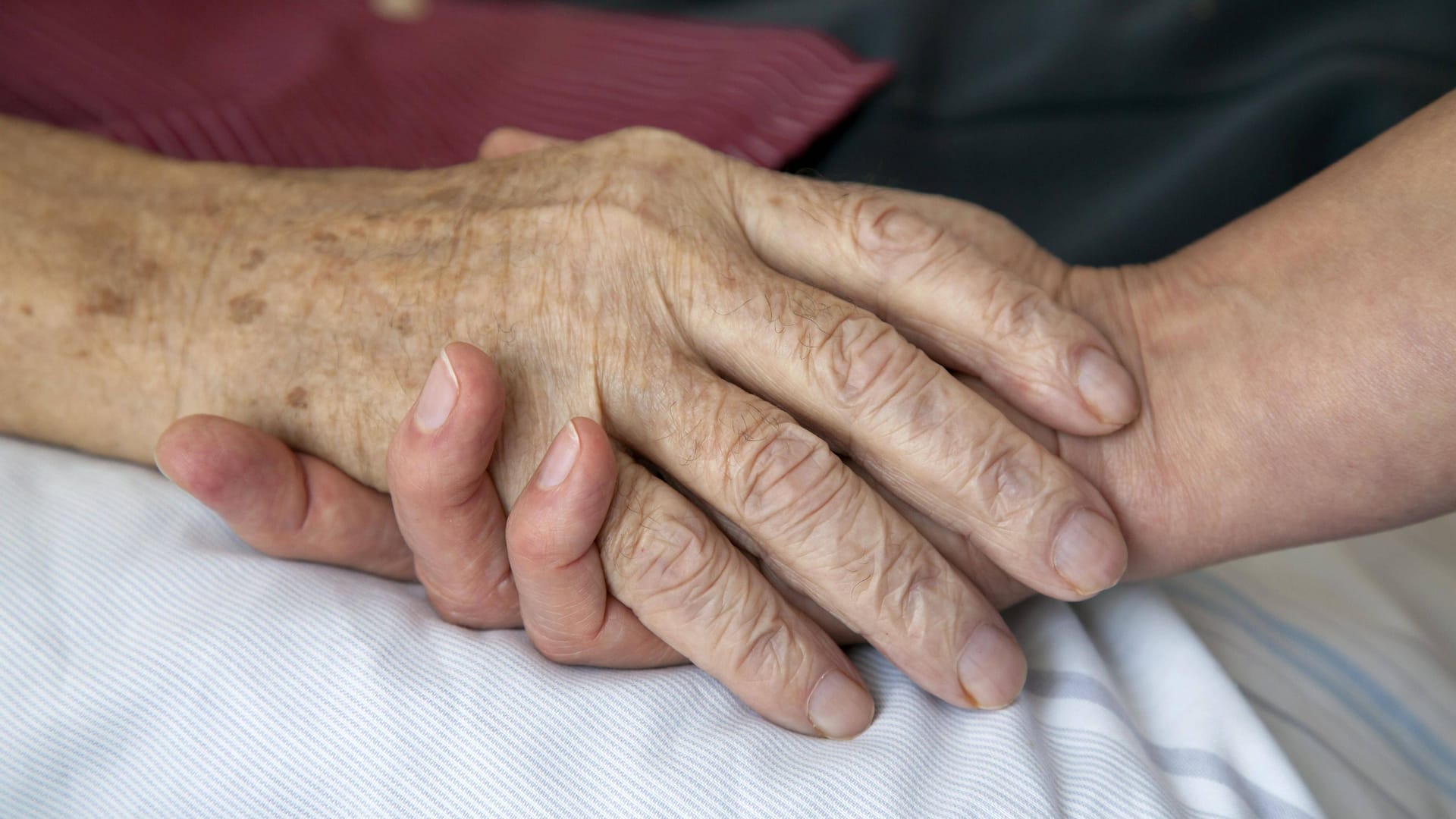 Pflegerin hält Hand eines sterbenden Mannes (Symbolfoto): Ein Berliner Arzt soll zahlreiche Menschen auf dem Gewissen haben.