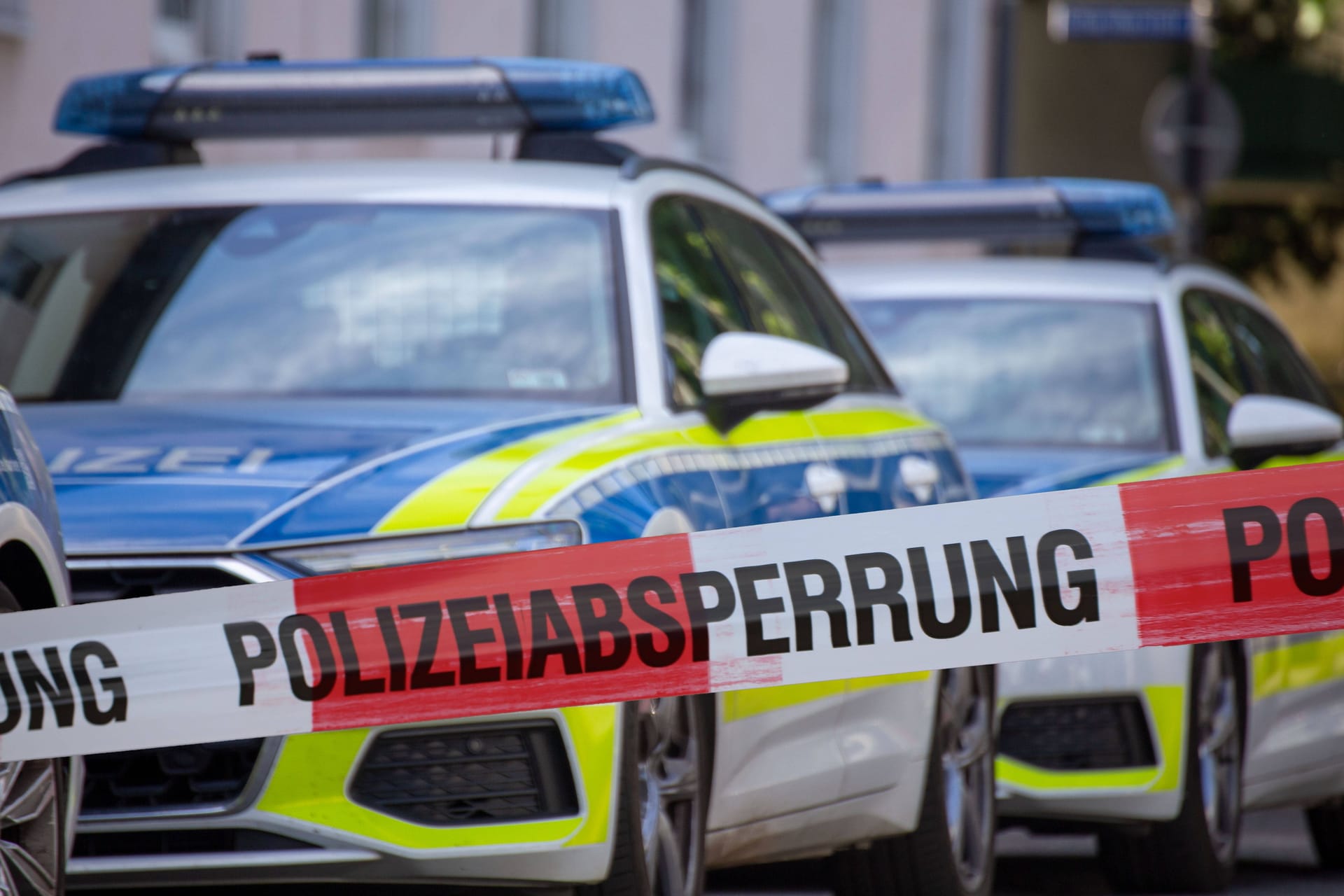Streifenwagen und Polizeiabsperrung (Archivbild): In Berlin ist ein Mann nach einer Messerattacke auf eine Frau und ihre Mutter festgenommen worden.