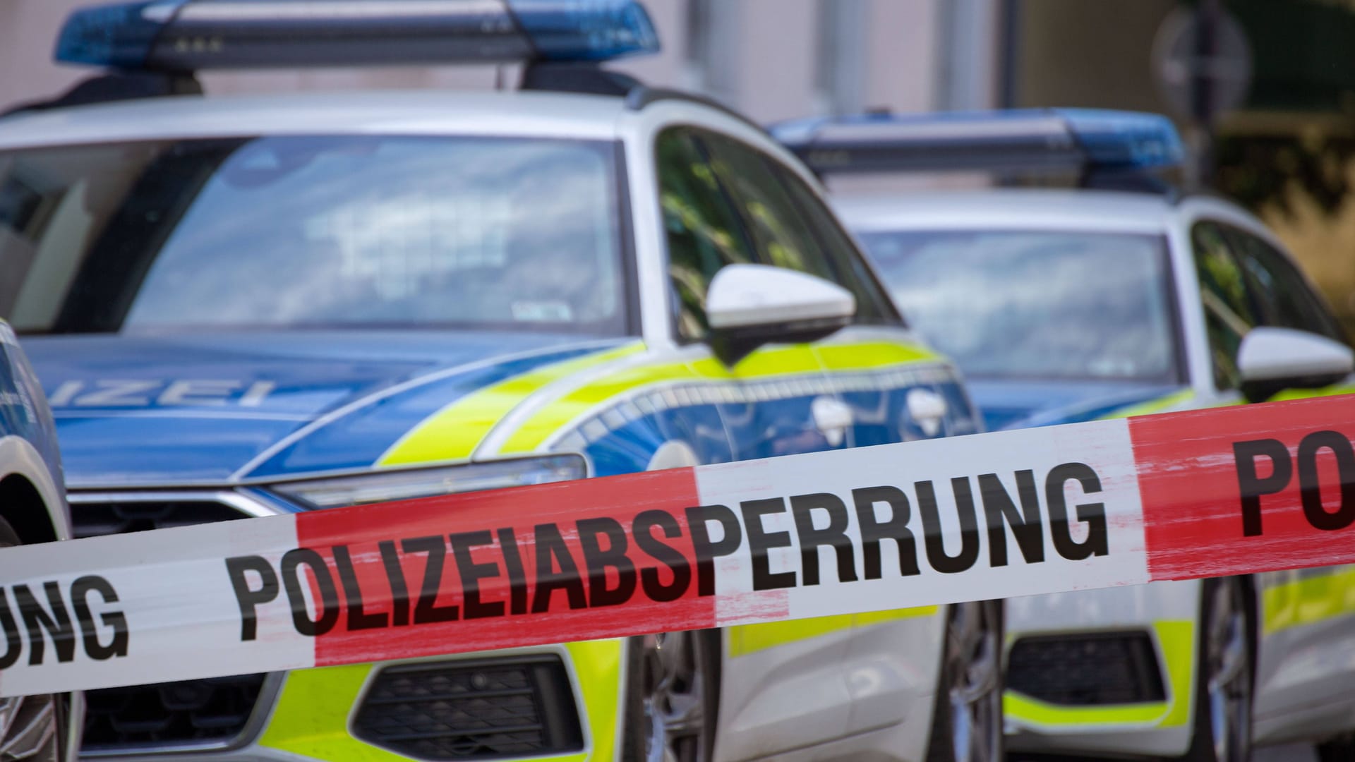 Streifenwagen und Polizeiabsperrung (Archivbild): In Berlin ist ein Mann nach einer Messerattacke auf eine Frau und ihre Mutter festgenommen worden.