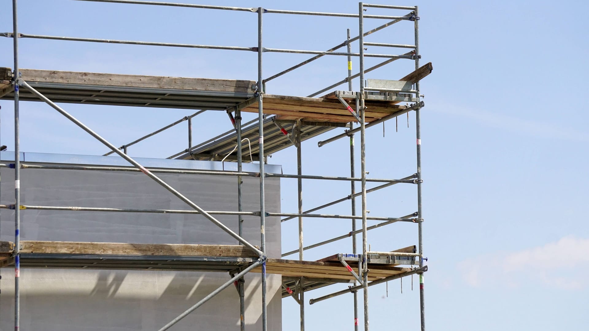 Ein Baugerüst an einem Haus (Symbolbild): Ein Mann ist bei Arbeiten in die Tiefe gestürzt.