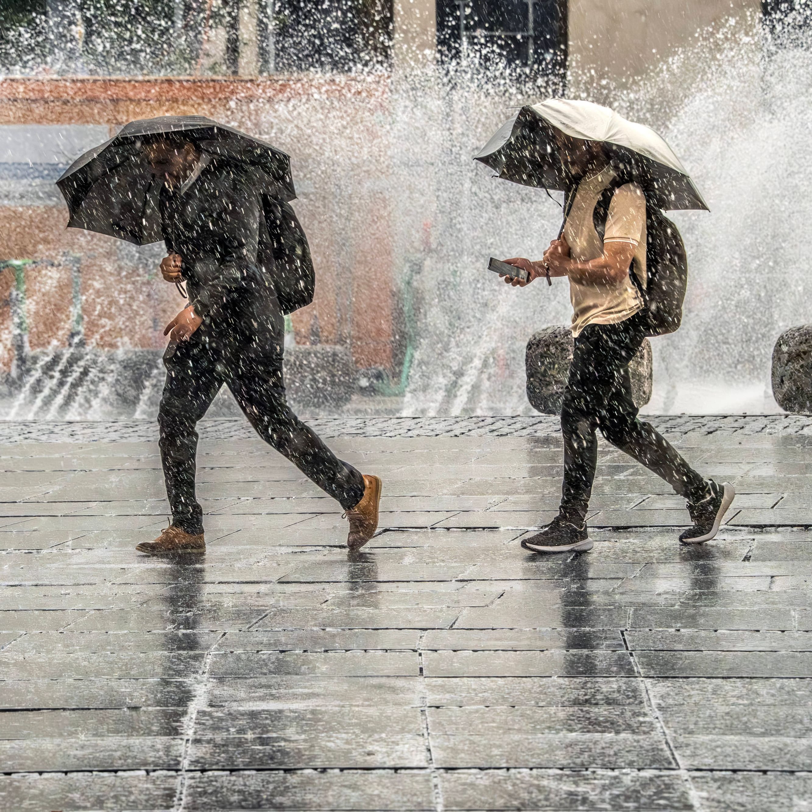 Zwei Menschen in München flüchten vor Starkregen (Archivbild): Das Wetter in Deutschland wird in den kommenden Tagen nass.