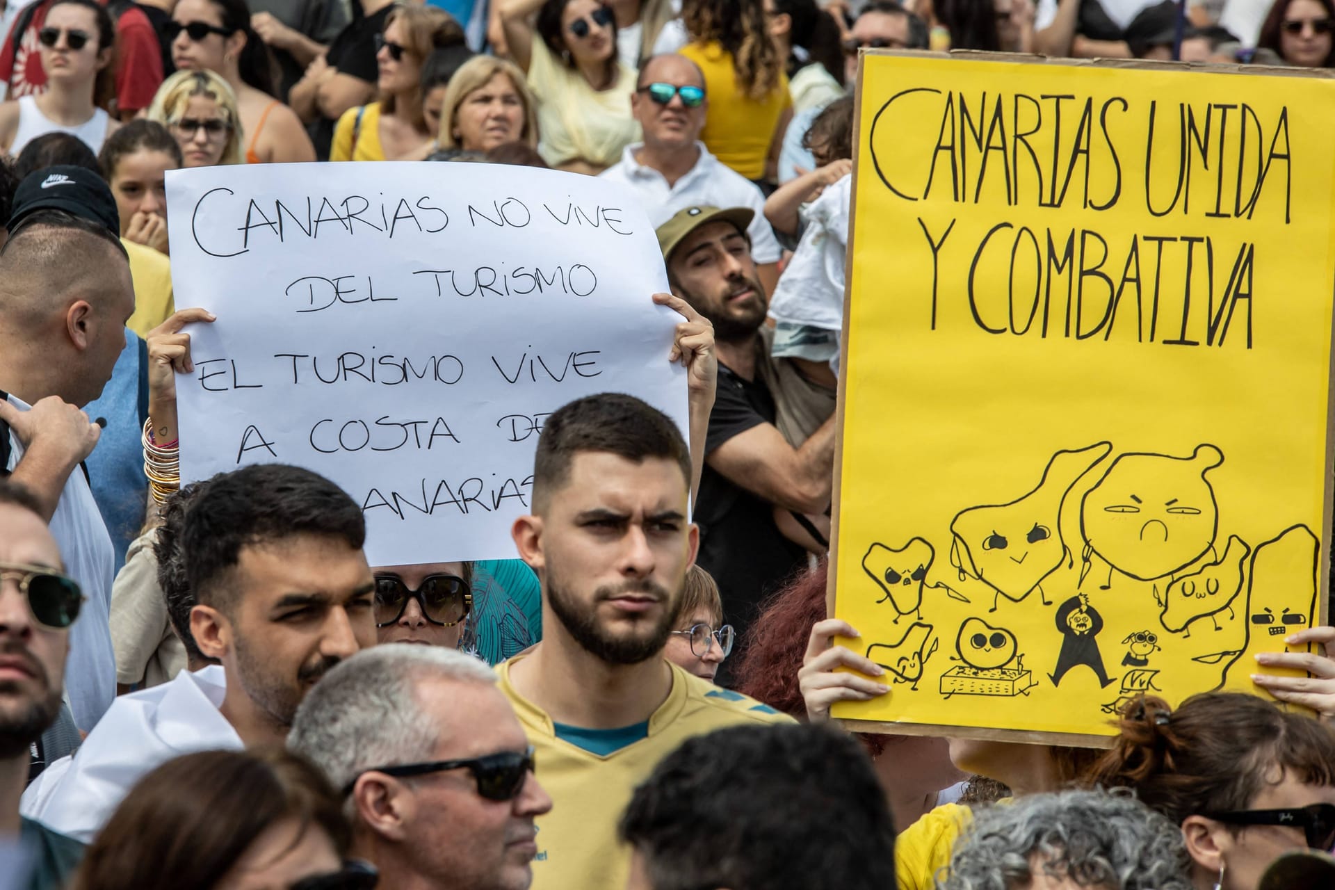 Demonstration gegen den Massentourismus auf Gran Canaria: Auf den Plakaten der Protestler heißt es: "Die Kanarischen Inseln leben nicht vom Tourismus" und "Kanarische Inseln im Kampf vereint".