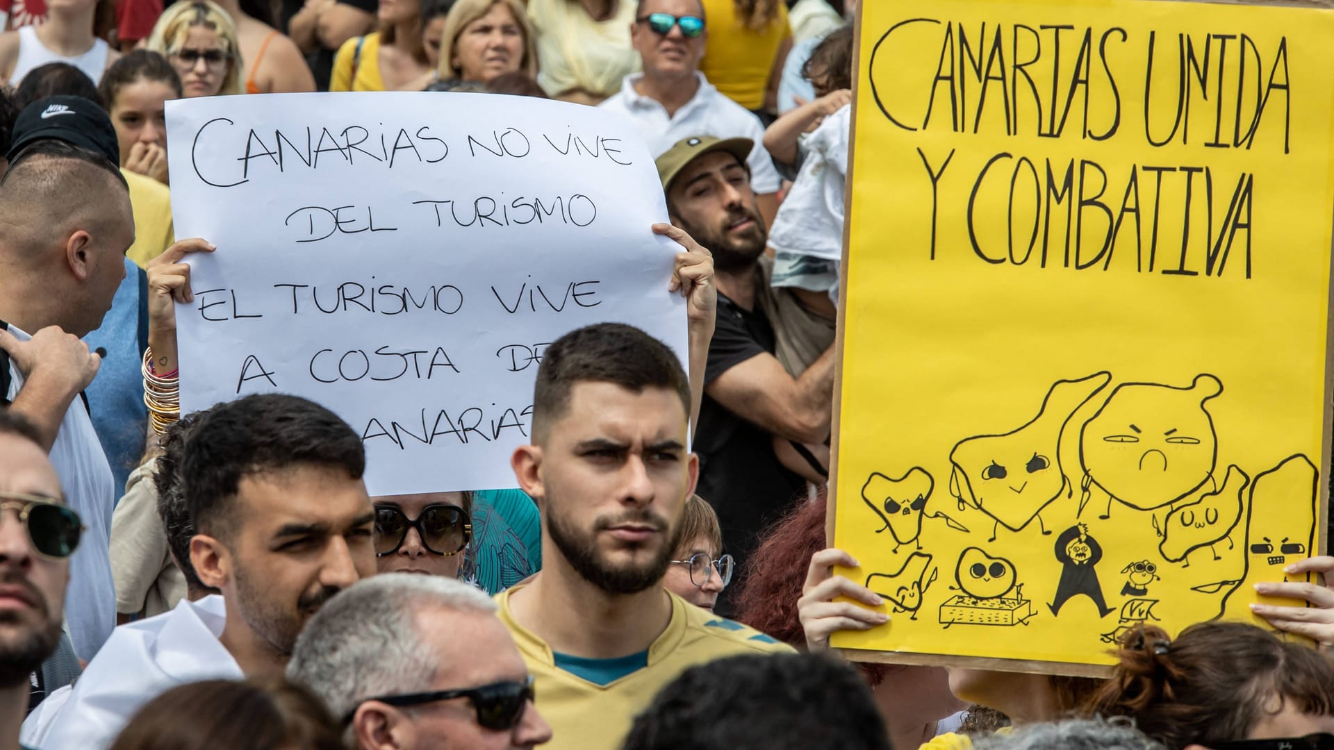 Demonstration gegen den Massentourismus auf Gran Canaria: Auf den Plakaten der Protestler heißt es: "Die Kanarischen Inseln leben nicht vom Tourismus" und "Kanarische Inseln im Kampf vereint".