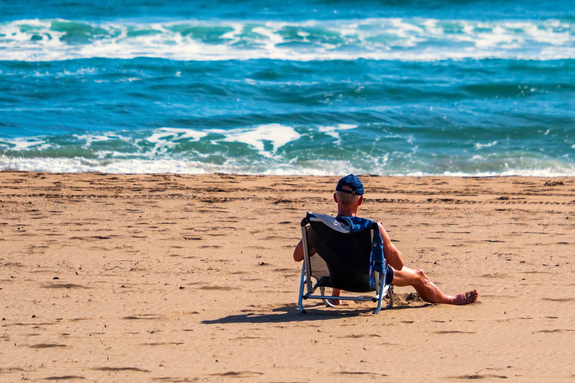 Ein einsamer Tourist am Strand von Roses, Katalonien.