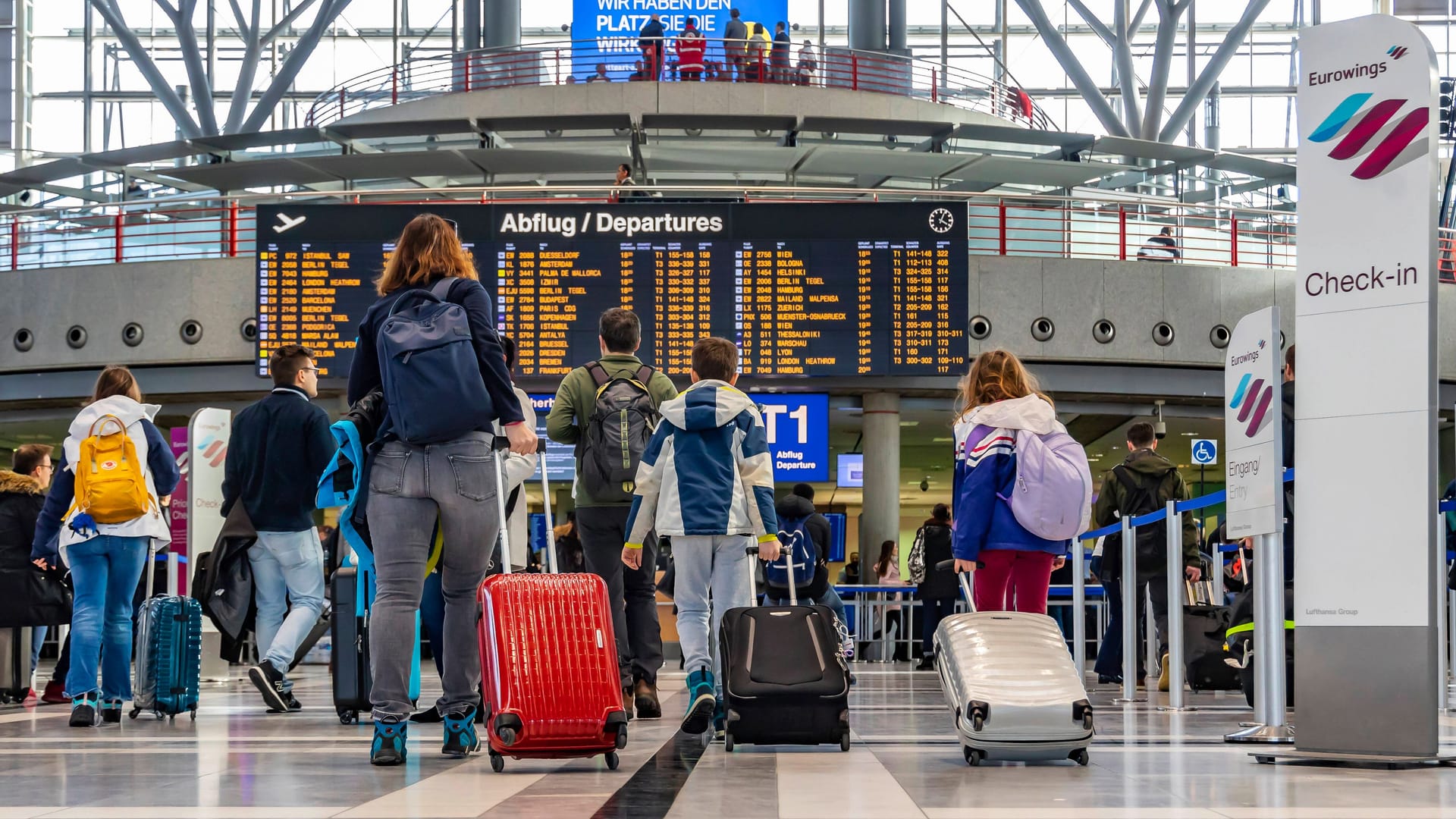 Reisende an einem Flughafen (Symbolfoto): Wer mit schulpflichtigen Kindern früher in den Urlaub startet, riskiert in Hamburg saftige Strafen.