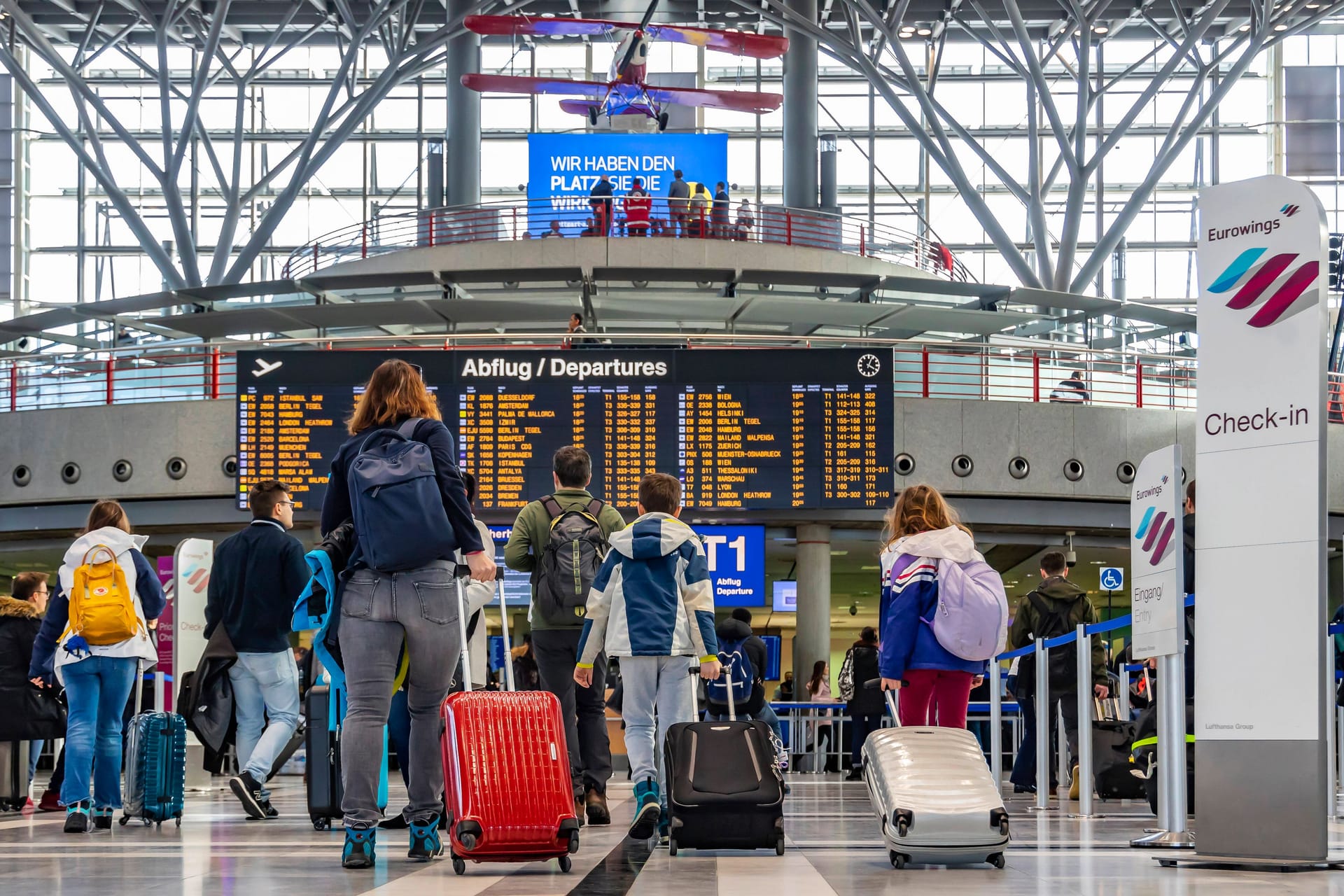 Reisende an einem Flughafen (Symbolfoto): Wer mit schulpflichtigen Kindern früher in den Urlaub startet, riskiert in Hamburg saftige Strafen.