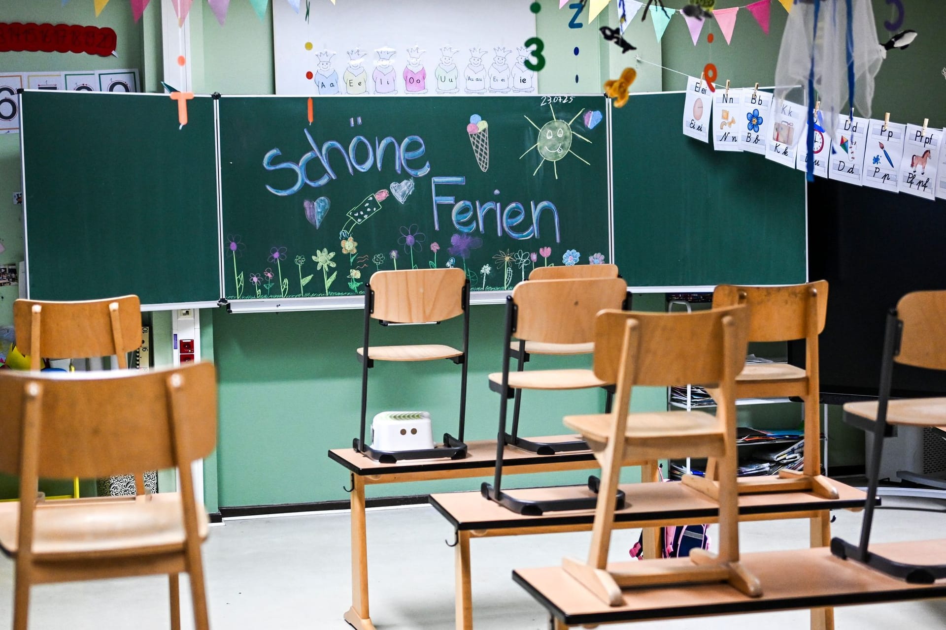 Hochgestellte Stühle und eine bemalte Tafel am letzten Schultag