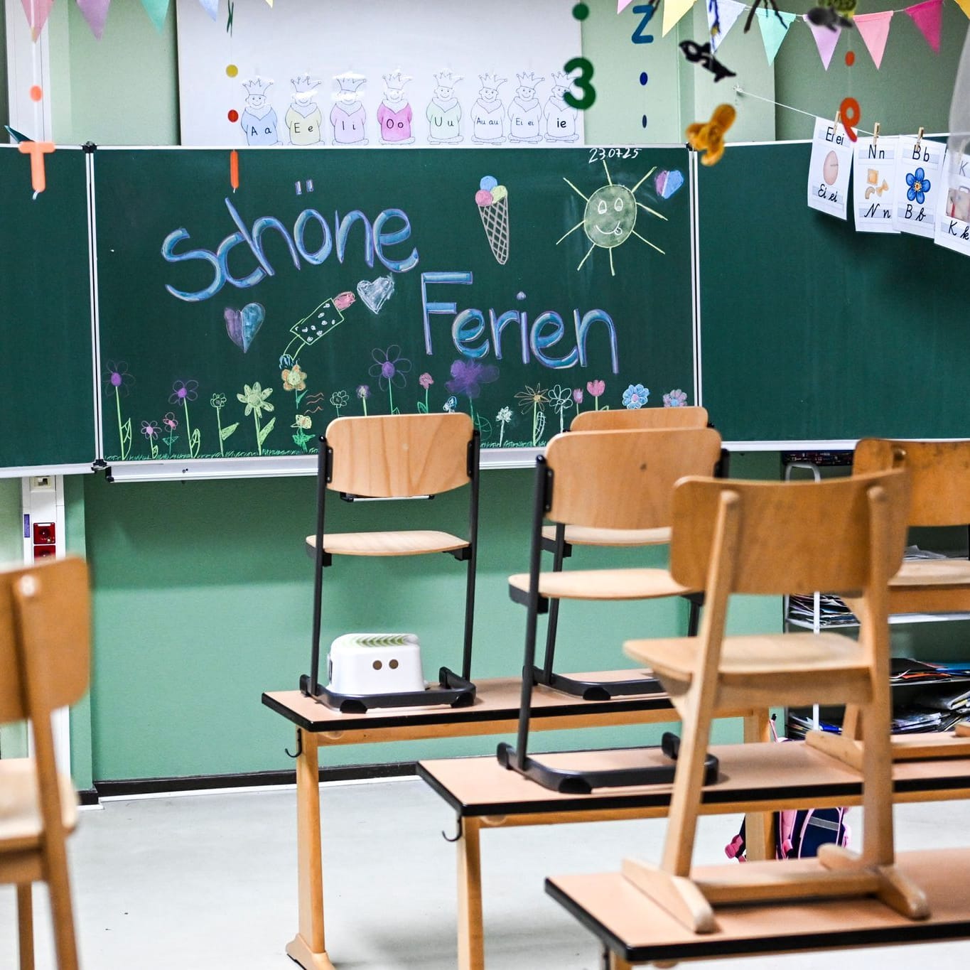 Hochgestellte Stühle und eine bemalte Tafel am letzten Schultag