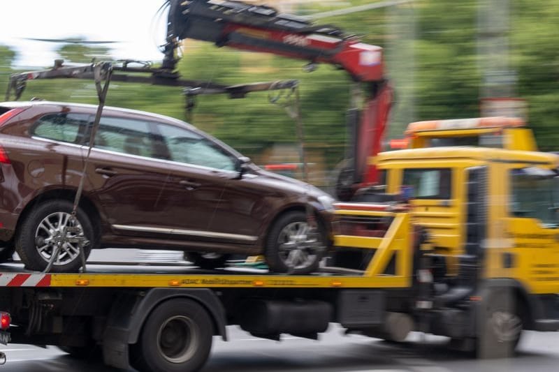 Ein Abschleppwagen mit einem Volvo fährt über eine Straße (Symbolbild): Die Grünen fordern mehr finanzielle Mittel und Personal für die Bußgeldstelle.