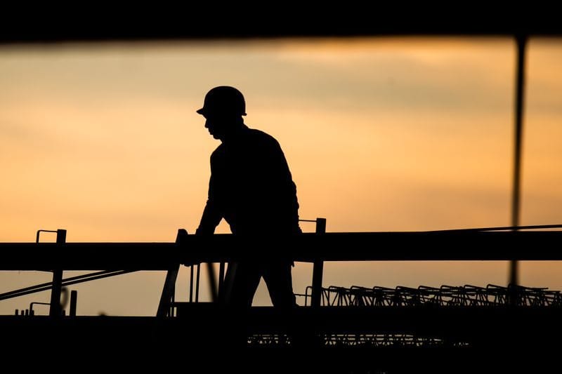 Die Silhouette eines Bauarbeiters (Symbolbild): In manchen Berufsbildern – etwa in der Baubranche – herrscht Bewerbermangel.