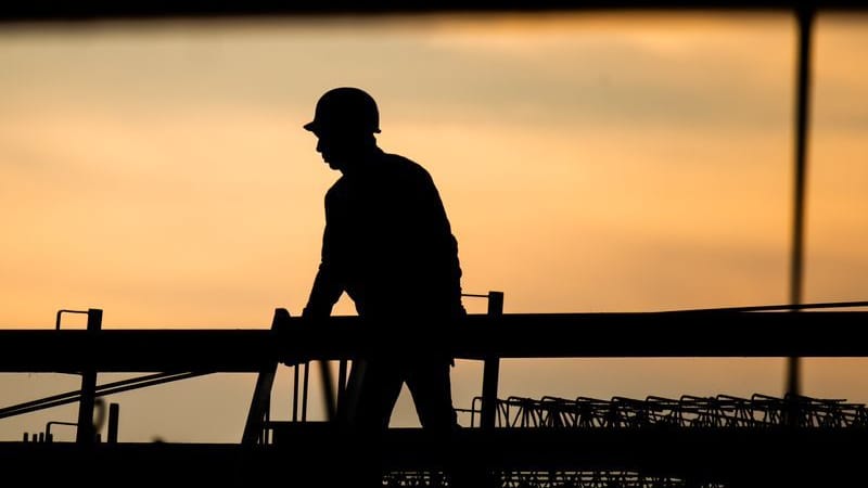 Die Silhouette eines Bauarbeiters (Symbolbild): In manchen Berufsbildern – etwa in der Baubranche – herrscht Bewerbermangel.