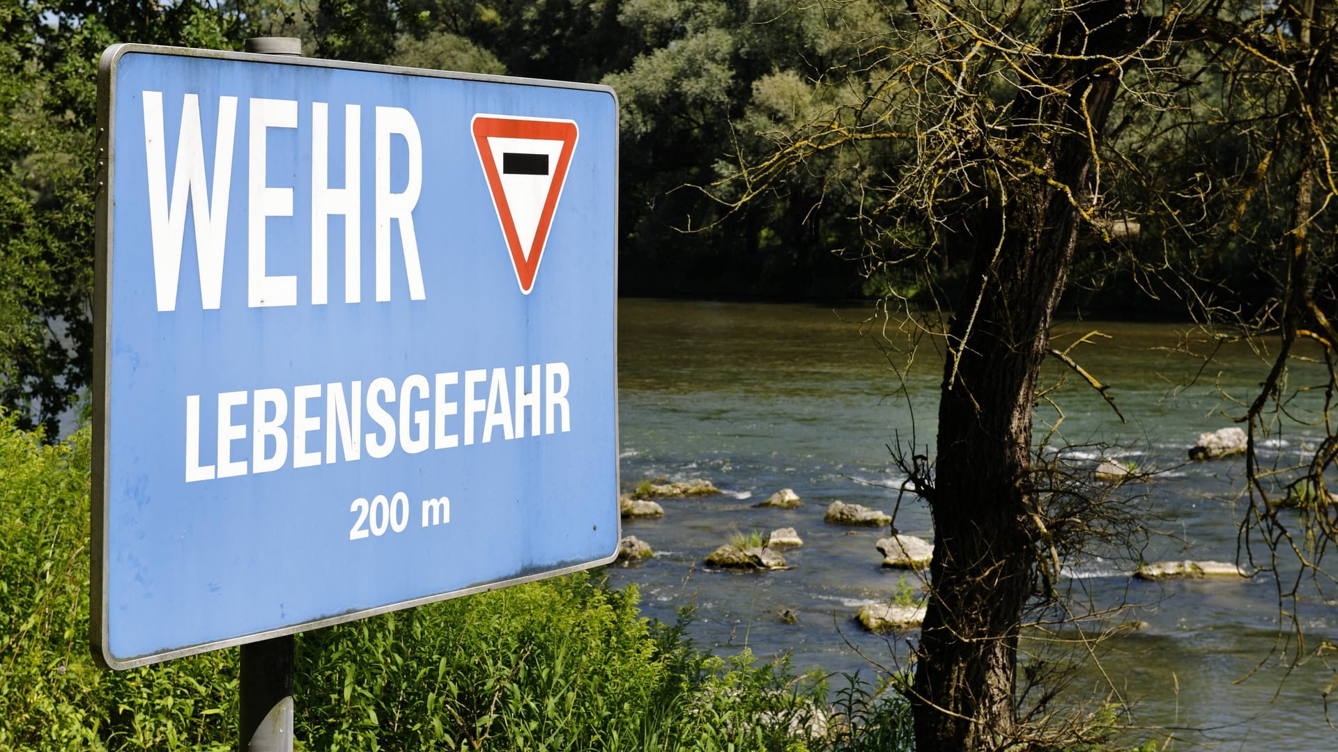 Ein Warnschild weist auf die Lebensgefahr an einer Wehranlage an der Isar hin (Archivbild): Die fünf Insassen des Bootes konnten sich eigenständig aus dem Wasser retten.