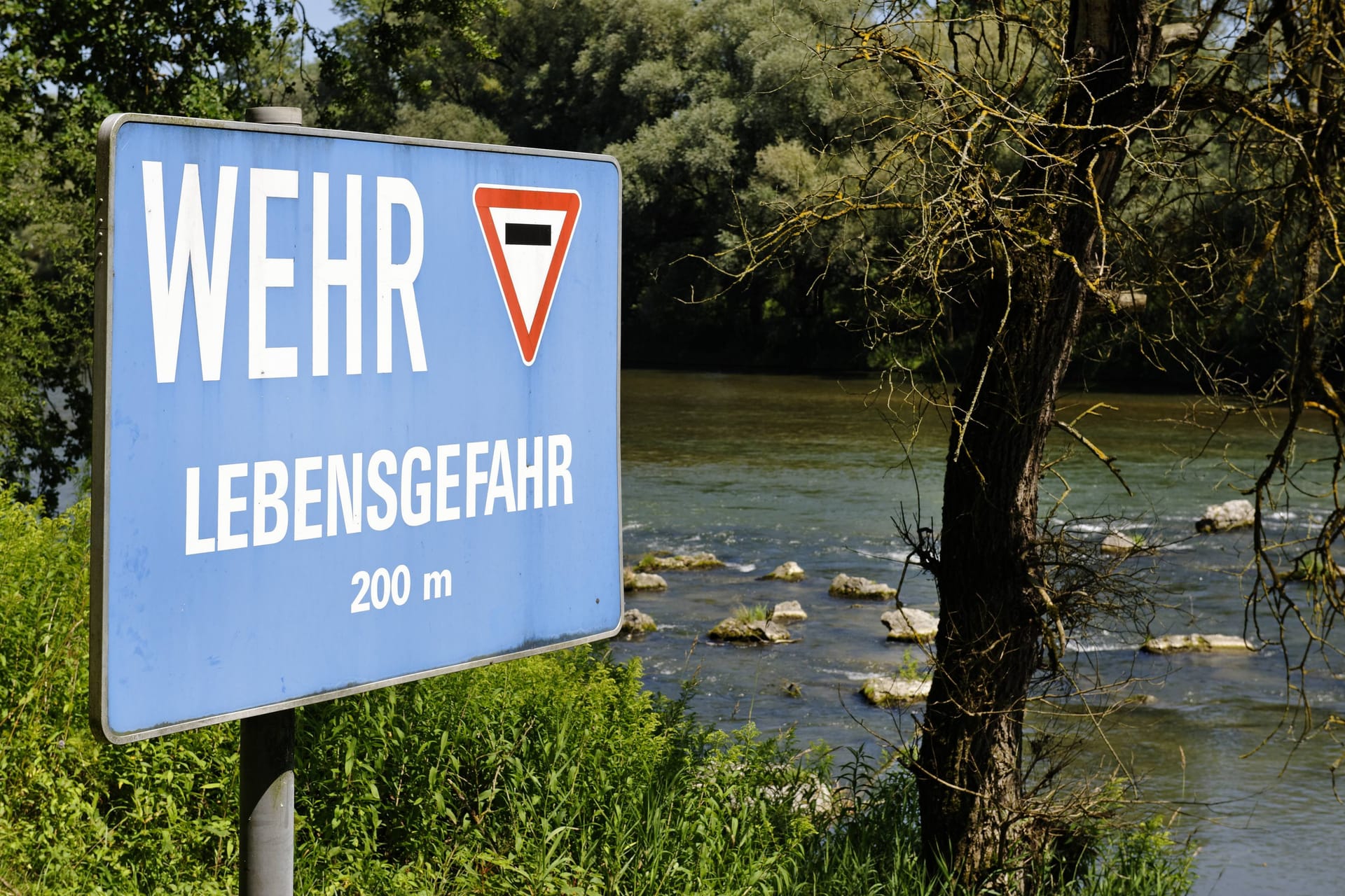 Ein Warnschild weist auf die Lebensgefahr an einer Wehranlage an der Isar hin (Archivbild): Die fünf Insassen des Bootes konnten sich eigenständig aus dem Wasser retten.