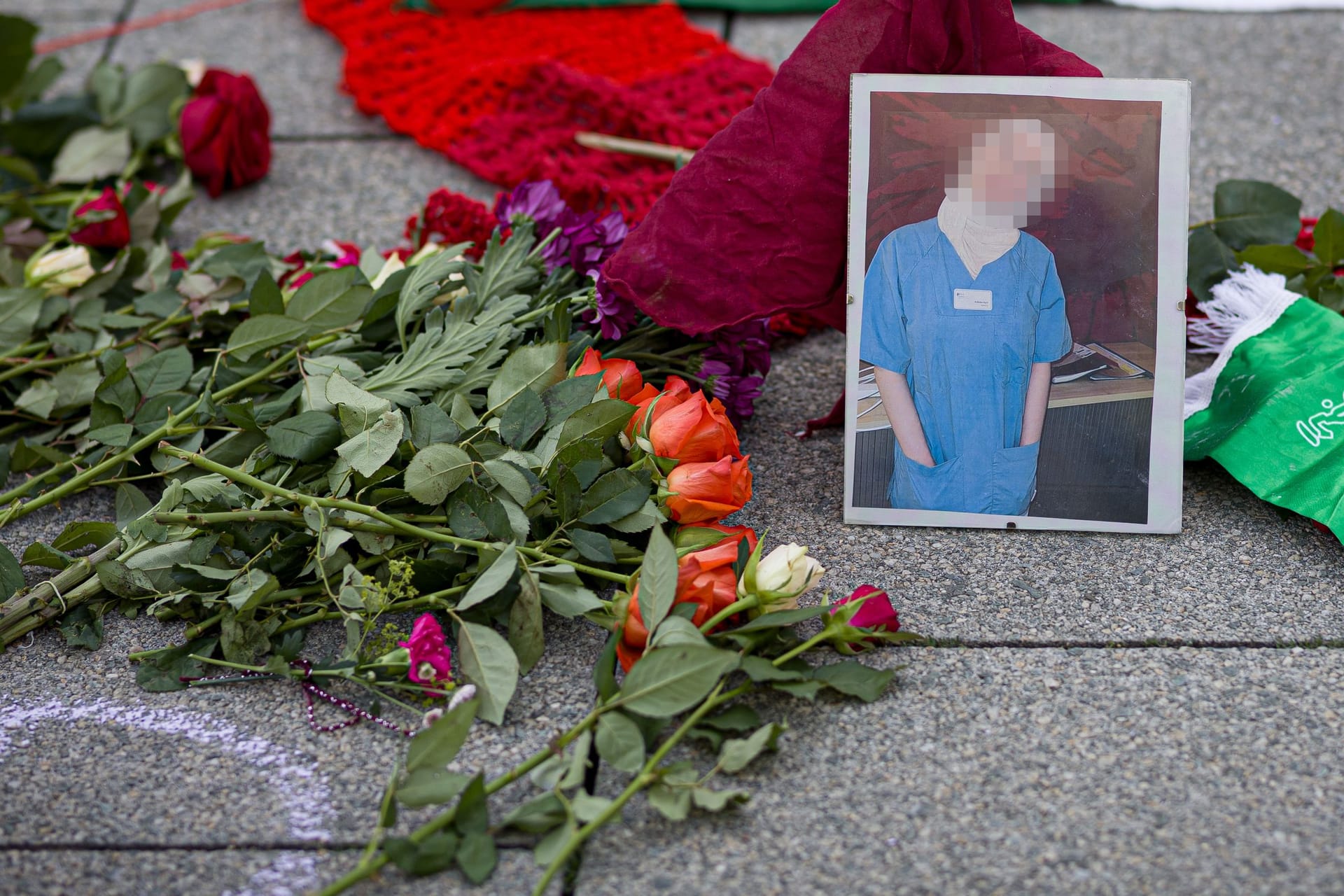 Blumen liegen neben einem Porträtfoto der getöteten Rahma A.: Rund 100 Menschen trauerten am Freitag öffentlich um die junge Frau.