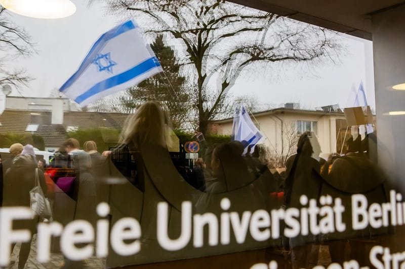 Eine Israel-Flagge spiegelt sich bei einem stillen Protest einer Initiative für die Sicherheit jüdischer Studierender in einer Scheibe (Archivbild): Nach einem Angriff klagt der jüdische Student Lahav Shapira gegen die Freien Universität Berlin.