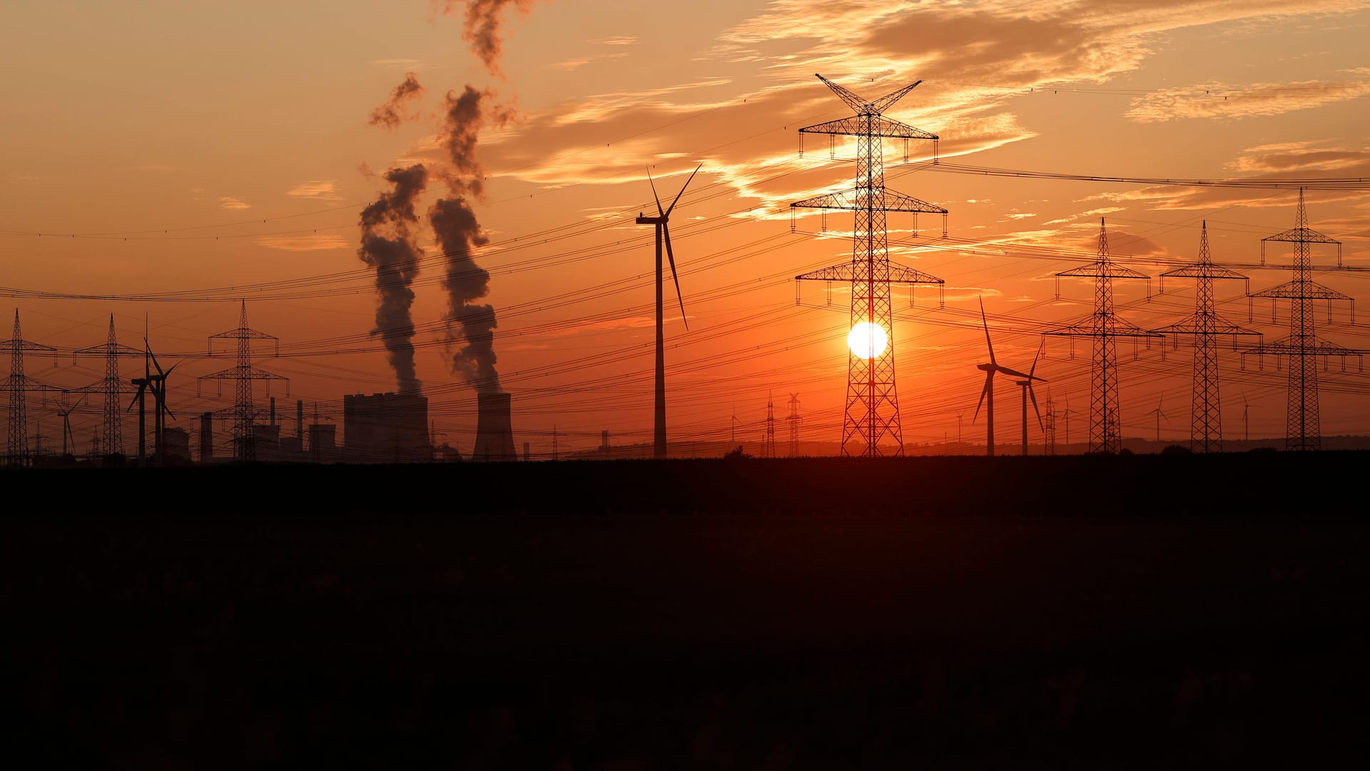 Strommasten und Windräder in NRW (Symbolfoto): In Aachen ist es am Mittwoch in Teilen der Stadt zu einem Stromausfall gekommen.