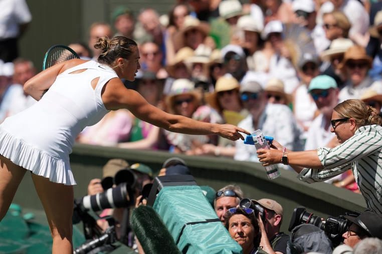 Hilfe vom Tennis-Superstar: Aryna Sabalenka reicht eine Wasserflasche ins Publikum.