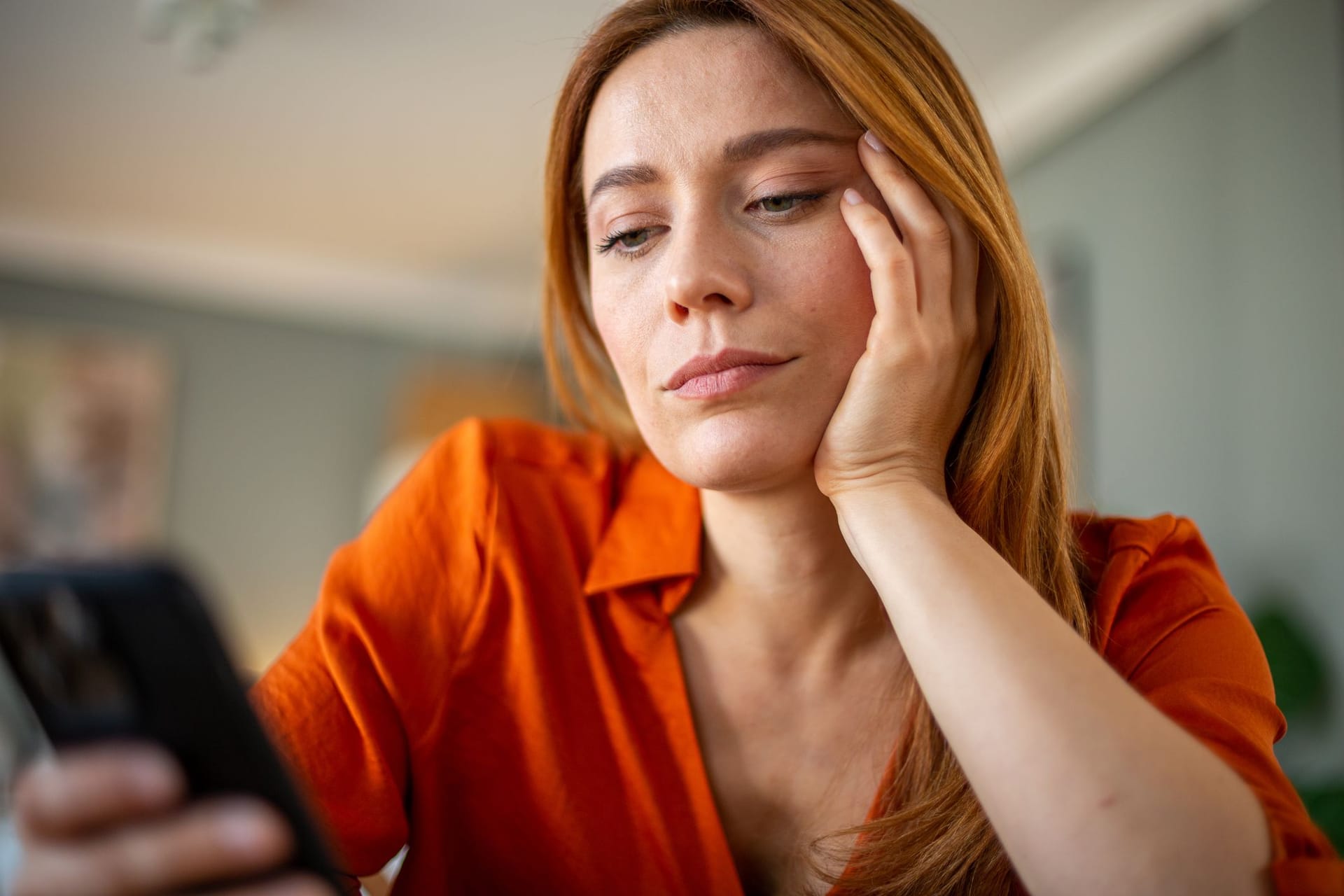 Eine junge Frau blickt aufs Handy: Die Sicherung des Rentenniveaus belastet vor allem jüngere Generationen stark.