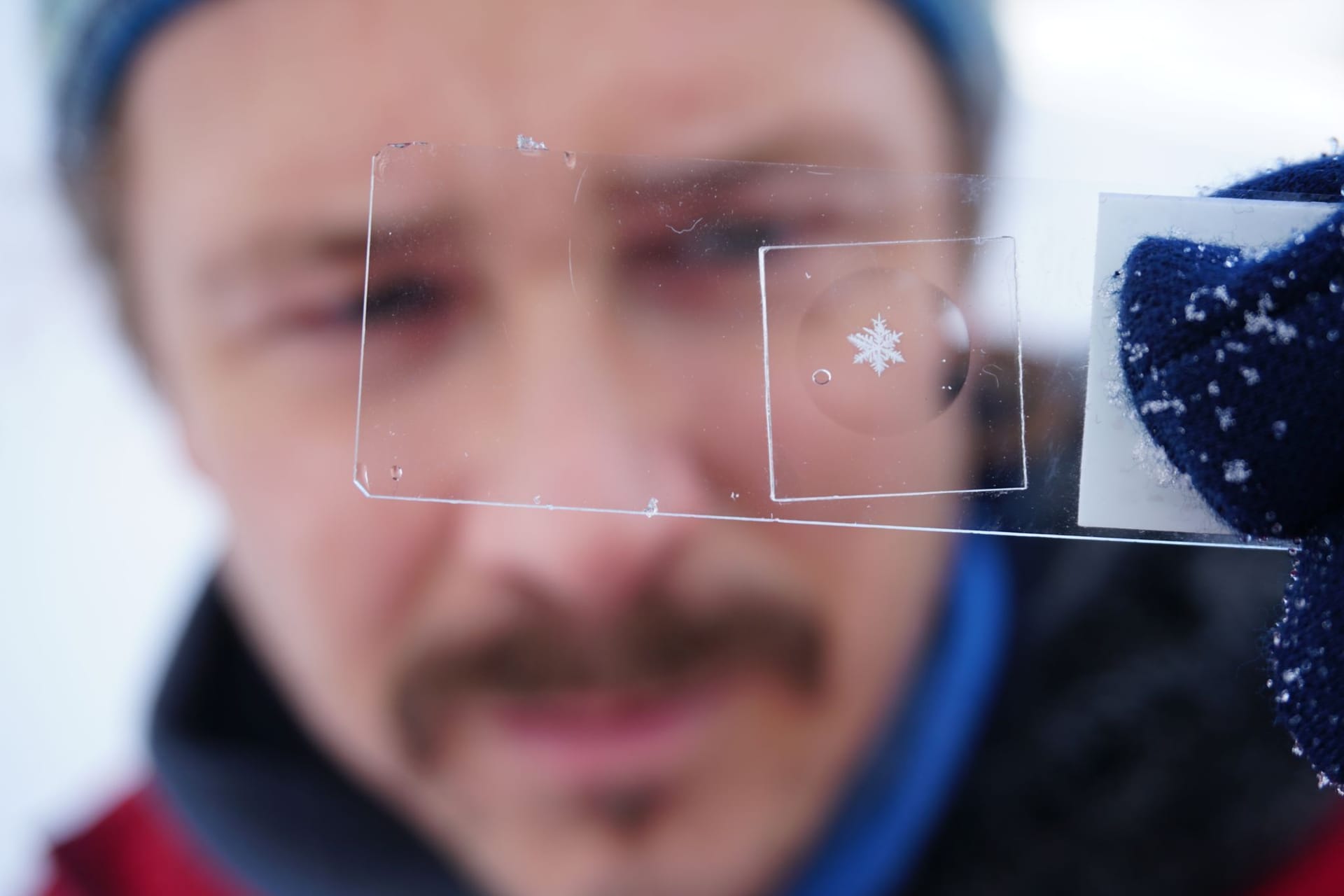 Paar verewigt Schneeflocken hinter Glas