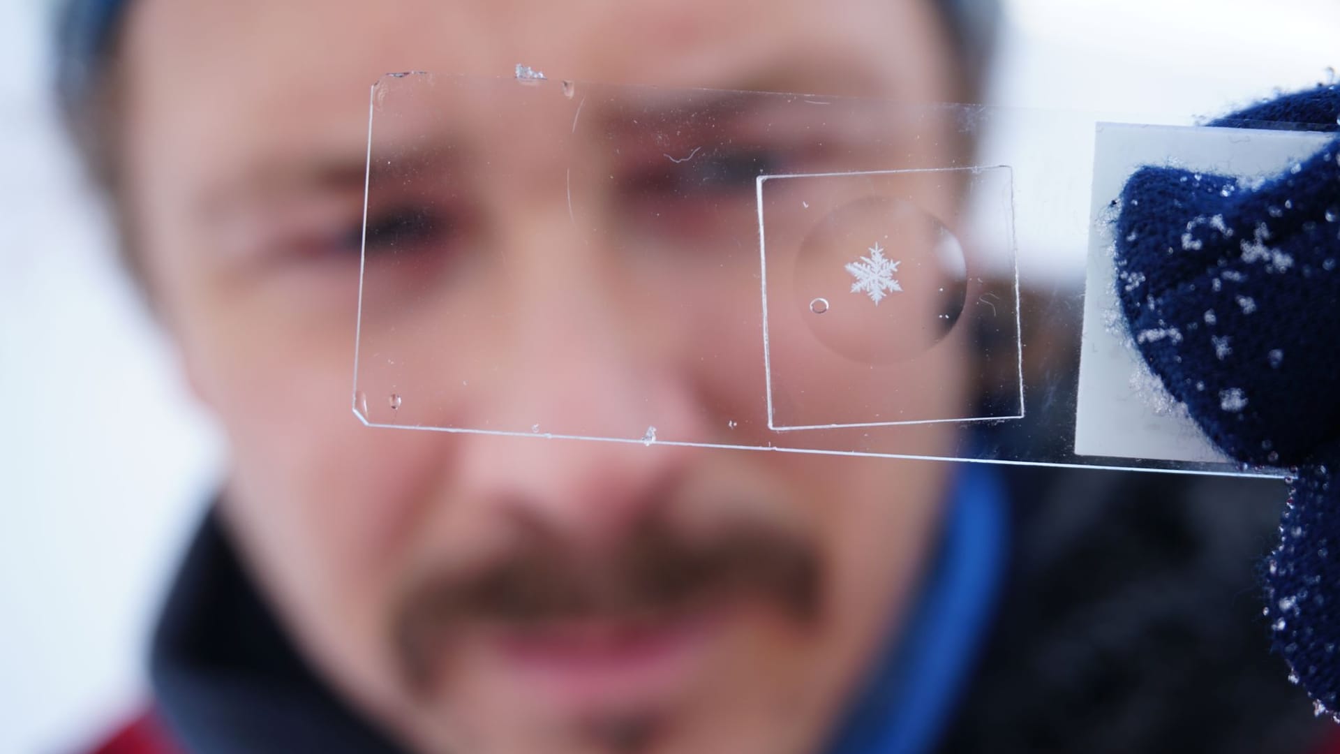 Paar verewigt Schneeflocken hinter Glas