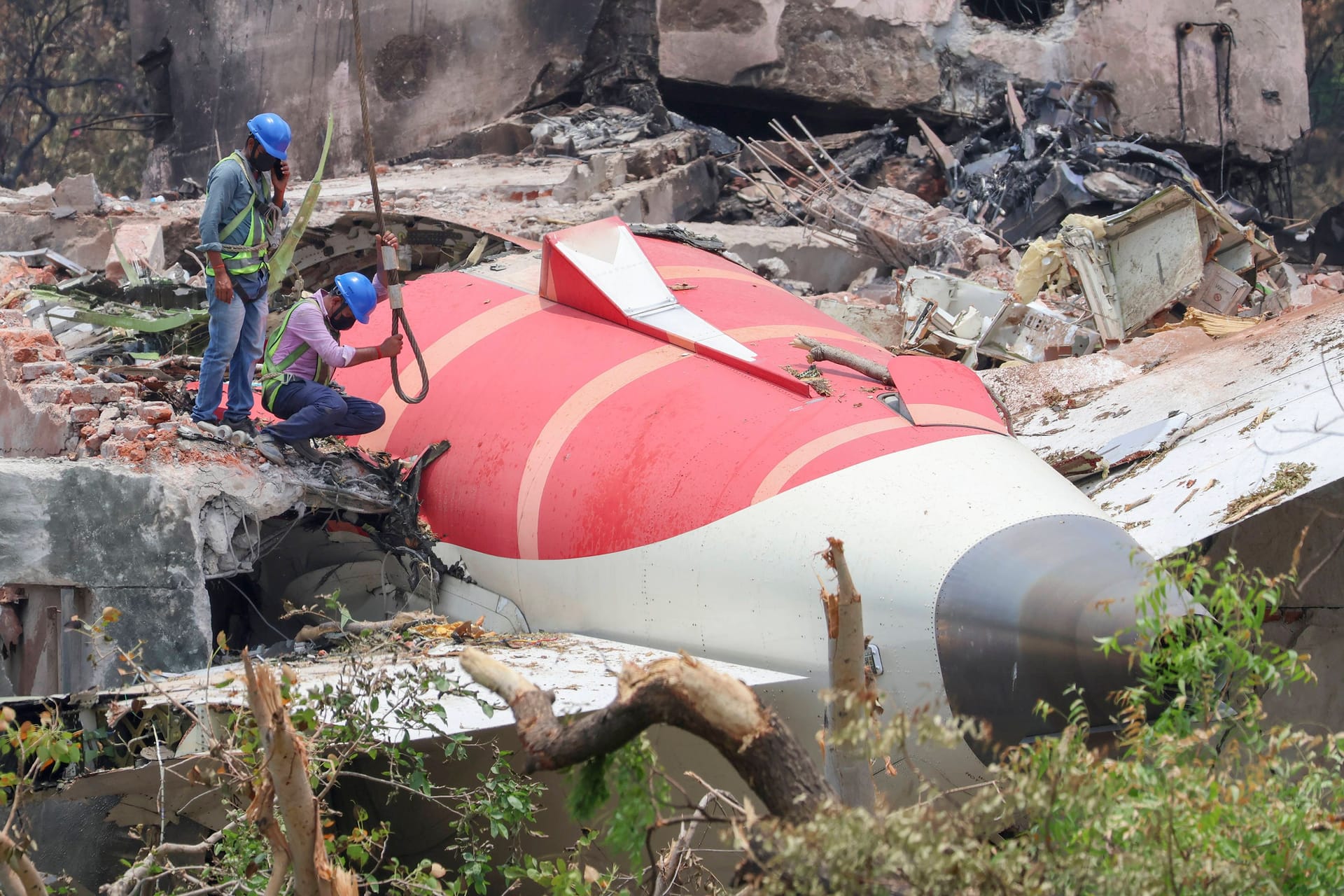 Experen bergen die Wrackteile der abgestürzten AIr India-Maschine in einem Wohnviertel von Ahmedabad.