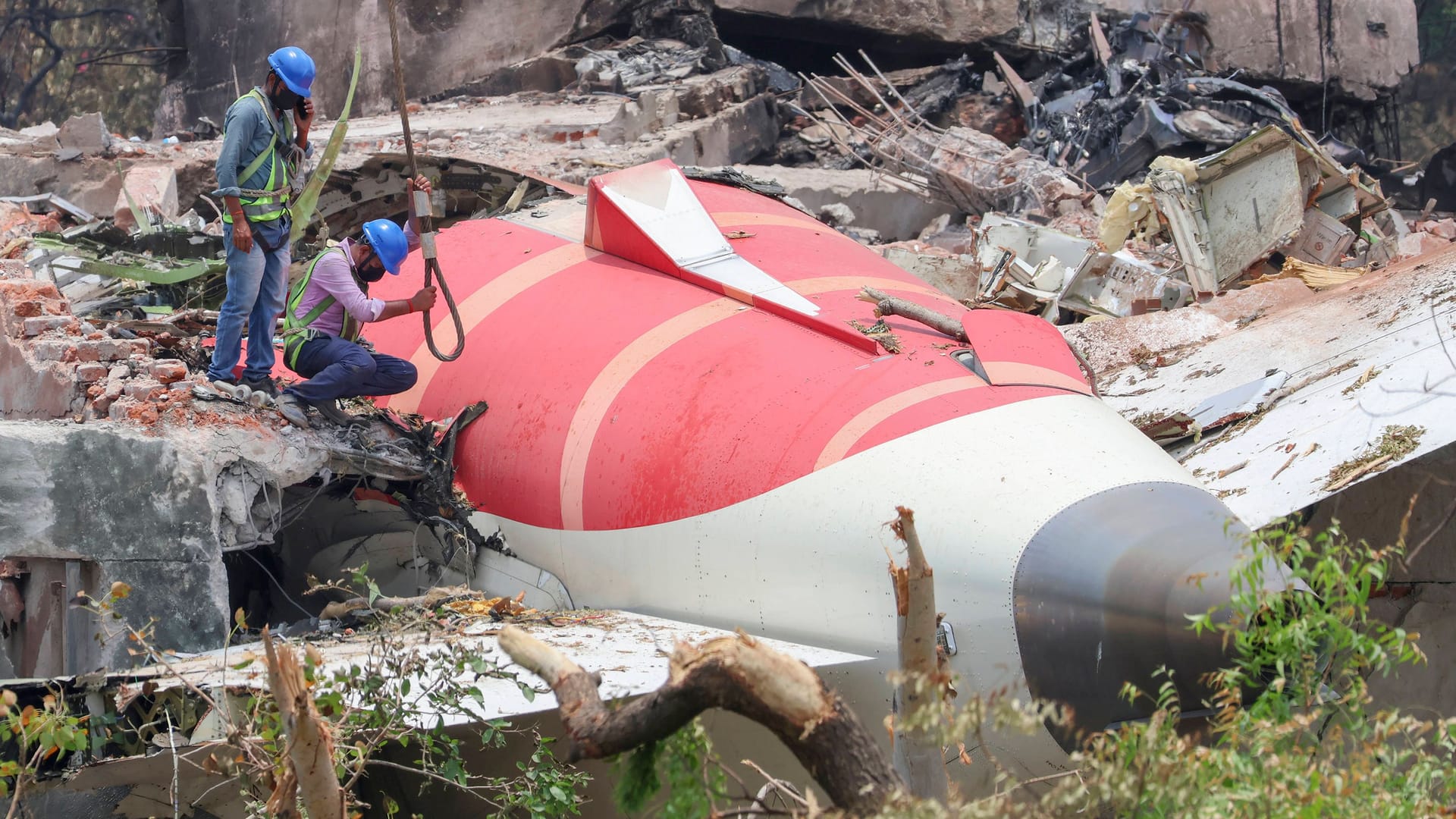 Experen bergen die Wrackteile der abgestürzten AIr India-Maschine in einem Wohnviertel von Ahmedabad.