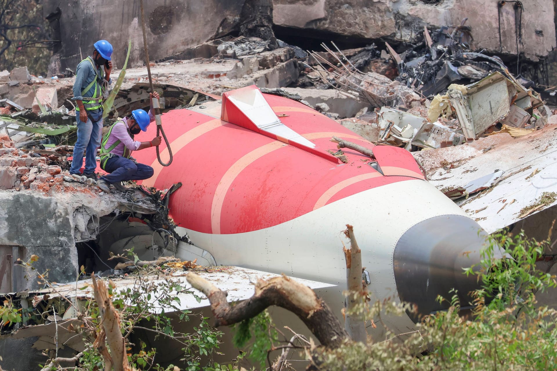 Experen bergen die Wrackteile der abgestürzten AIr India-Maschine in einem Wohnviertel von Ahmedabad.