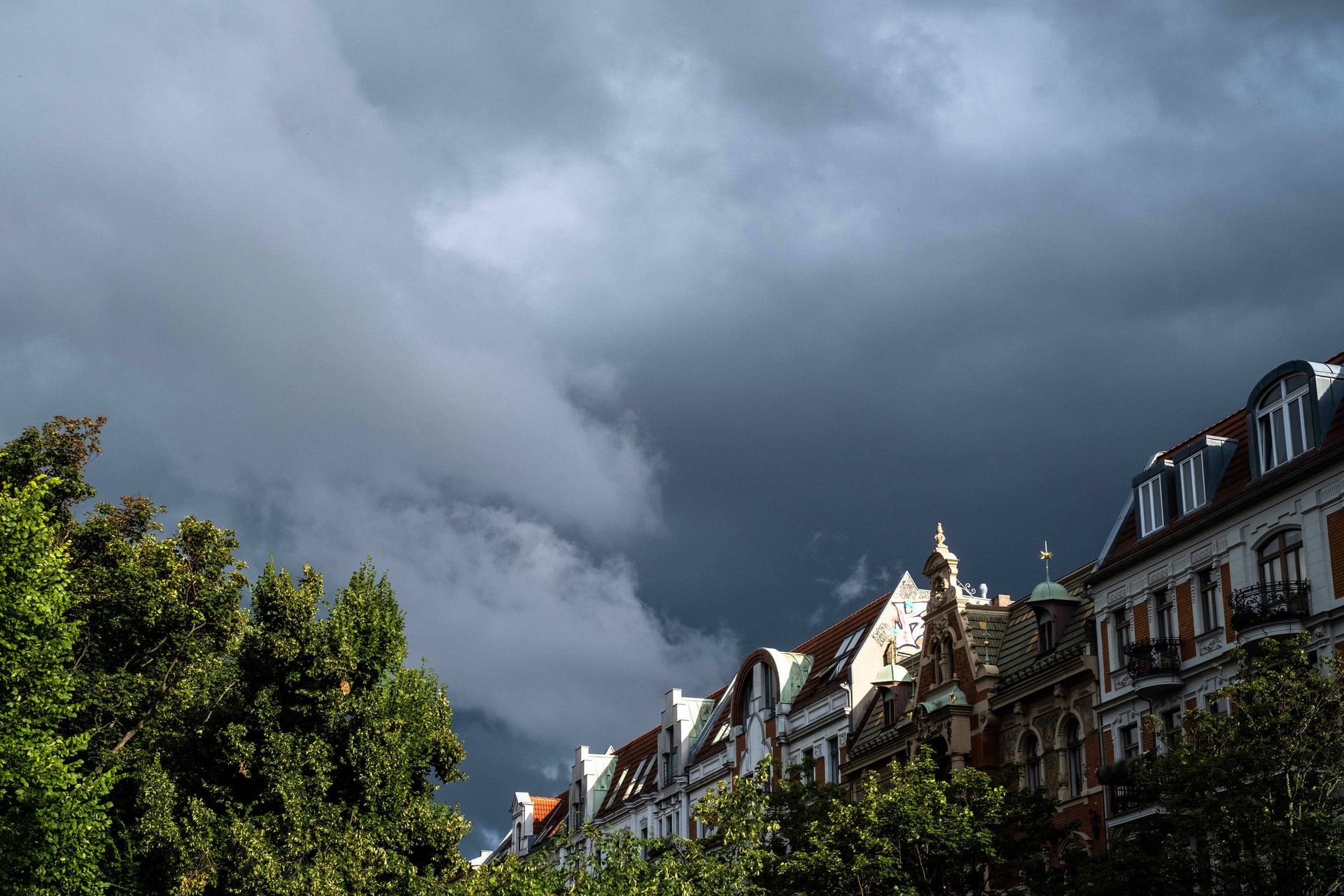 Dunkle Regenwolken über Wohnhäusern in Prenzlauer Berg: In Berlin wird es am Mittwochnachmittag ungemütlich.