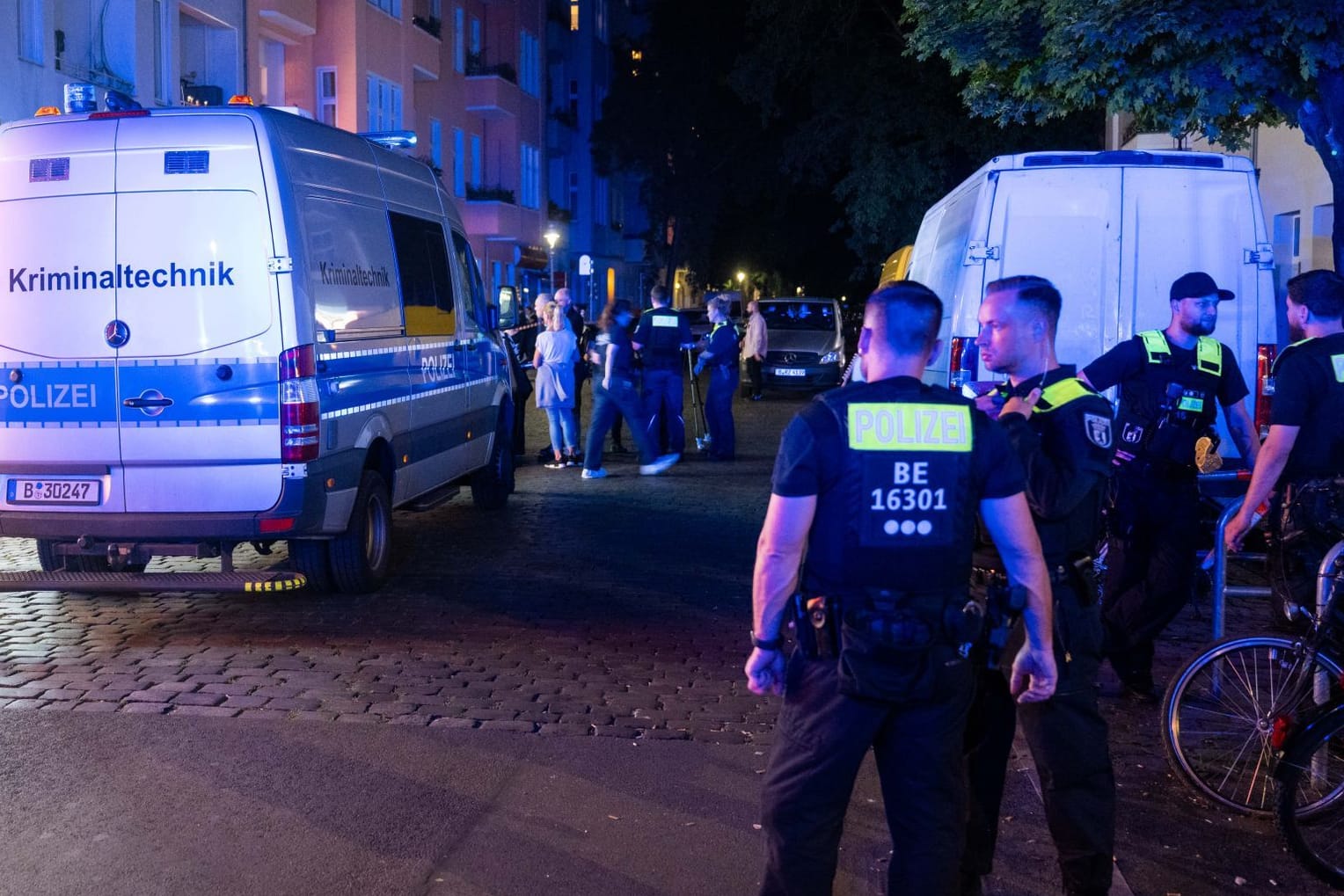 Polizisten stehen an einem Tatort. Ein Mann ist bei einer Auseinandersetzung mit 40 bis 60 Beteiligten in Berlin-Gesundbrunnen tödlich verletzt worden