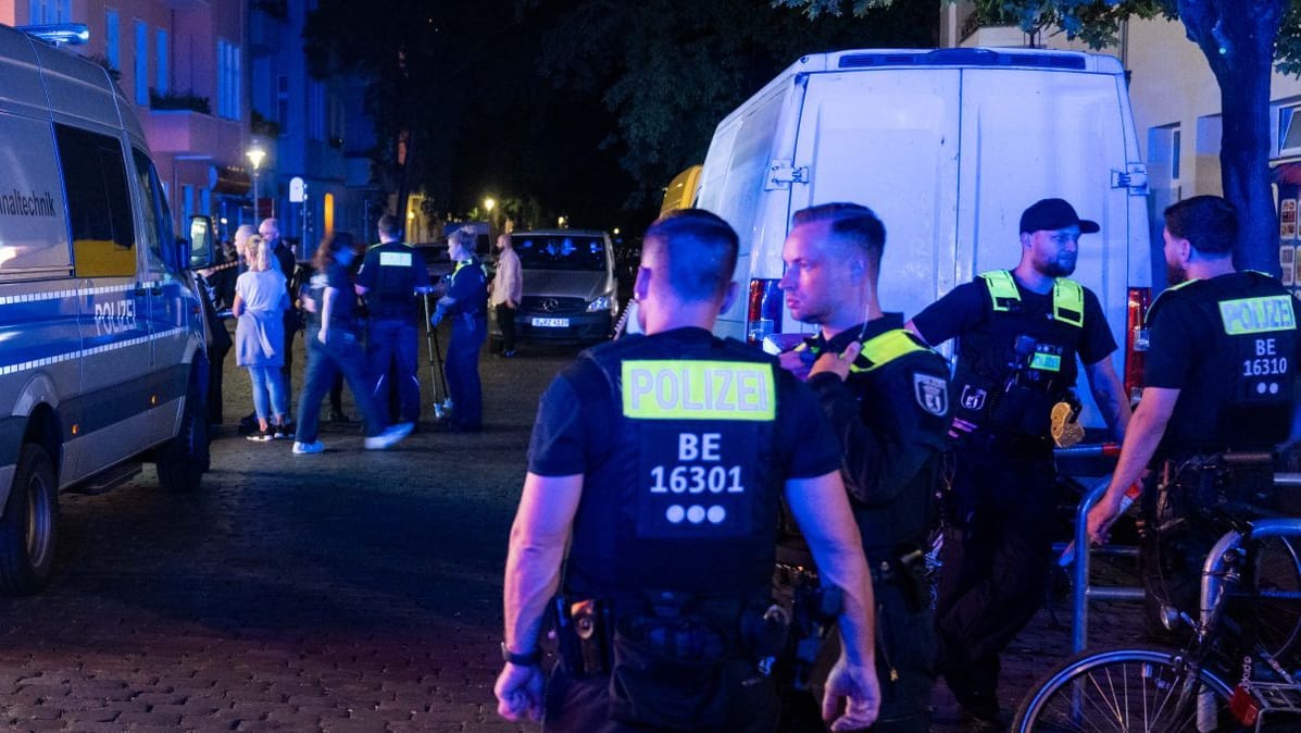 Polizisten stehen an einem Tatort. Ein Mann ist bei einer Auseinandersetzung mit 40 bis 60 Beteiligten in Berlin-Gesundbrunnen tödlich verletzt worden