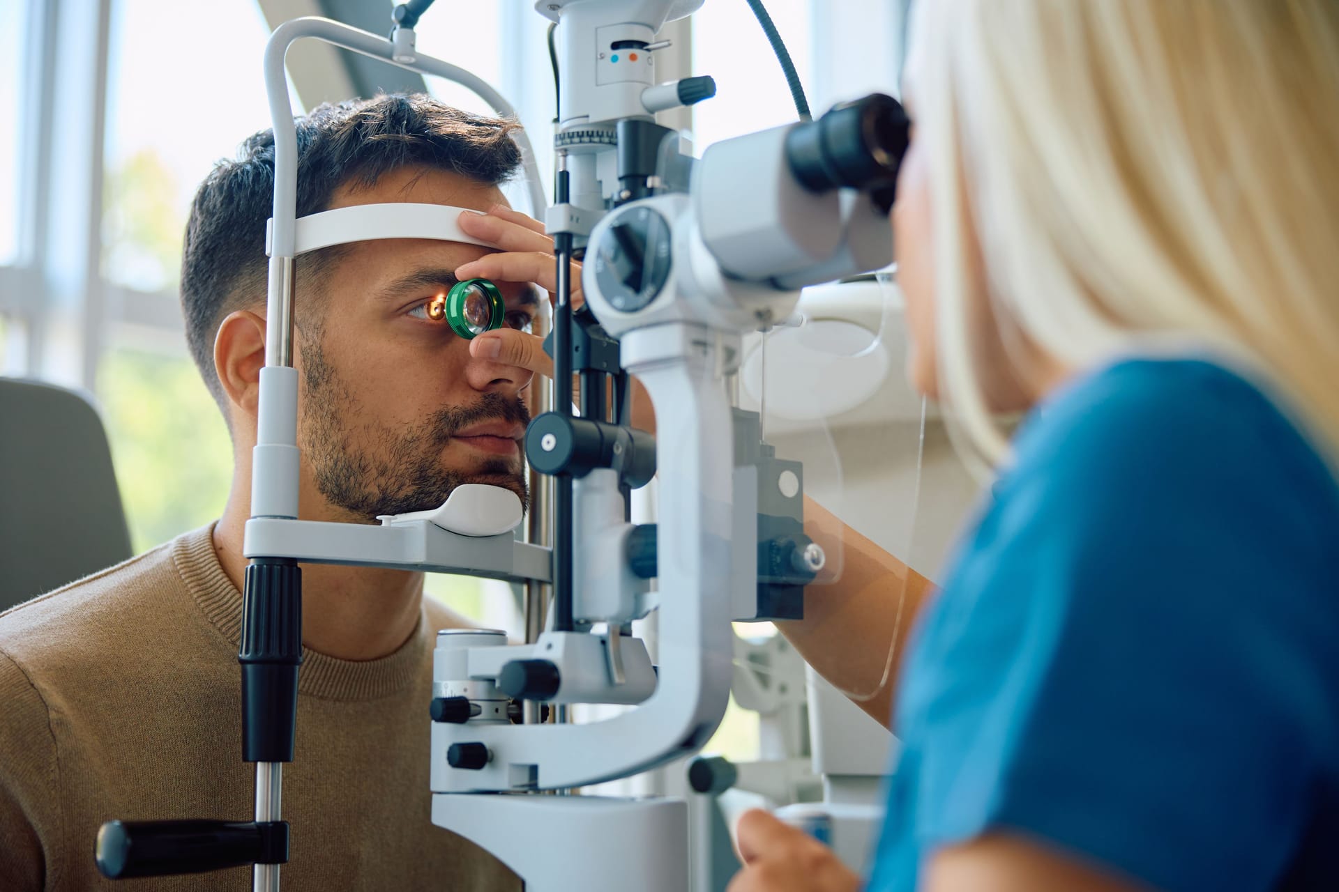 Augenärztin untersucht die Augen eines jungen Mannes: Sarkoidose kann zu Schäden an den Augen führen.