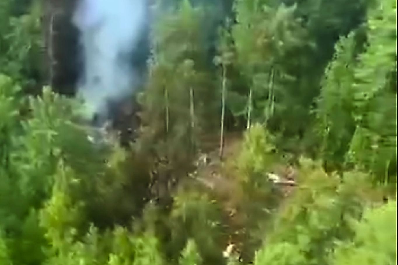 Russland, Tynda: Von der Absturzstelle des russischen Passagierflugzeugs des Typs An-24 steigt Rauch auf.