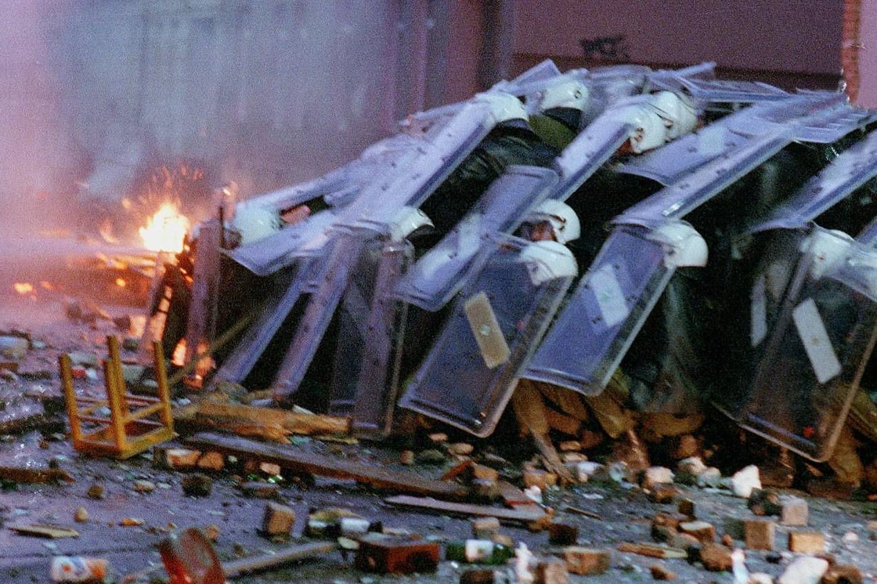 Polizisten schützen sich mit Schildern, links brennt ein Feuer (Archivbild): Auf Anwohner wirkten die "Chaostage" teils wie ein "Bürgerkrieg".