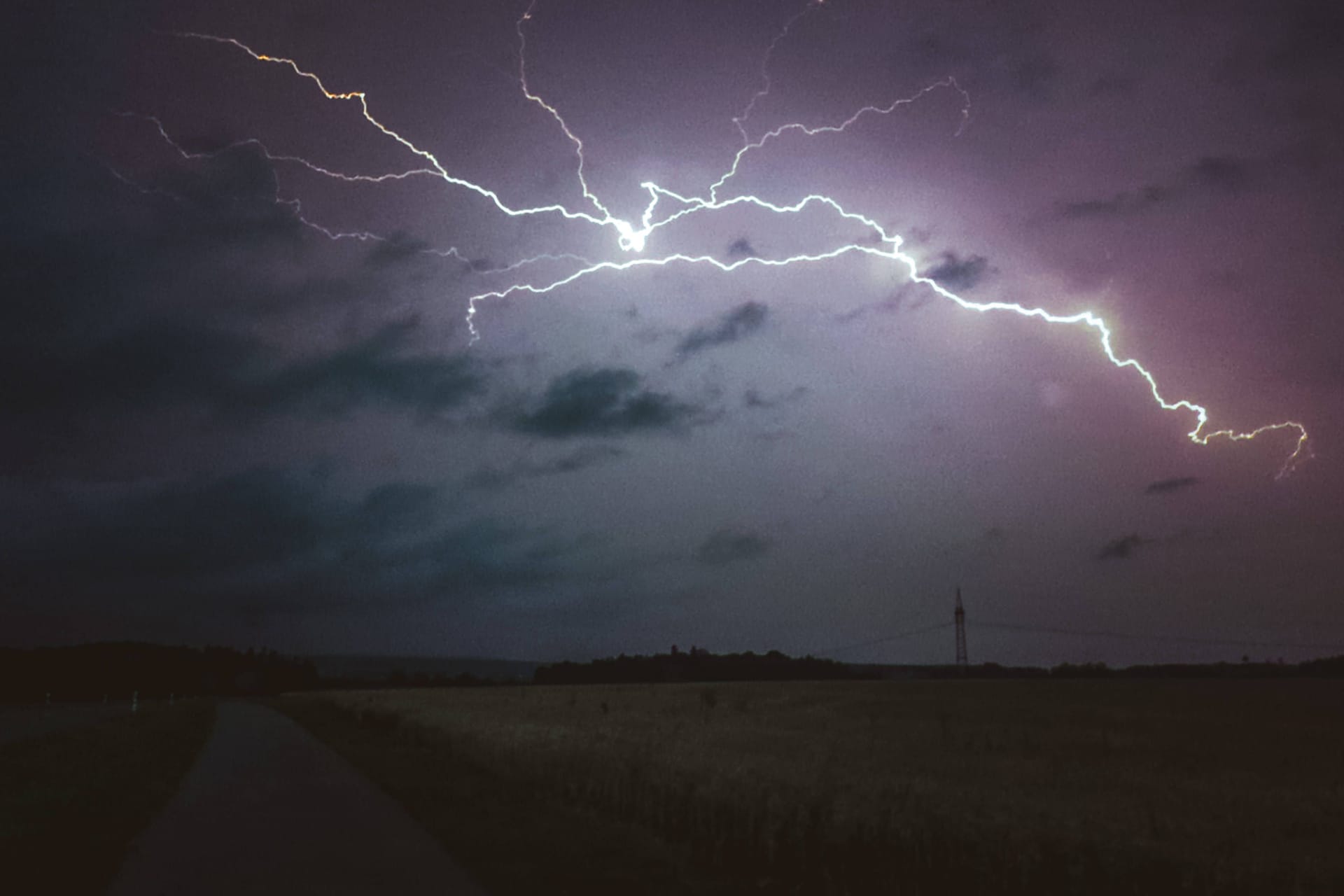 Blitze am Nachthimmel während eines Unwetters: In Köln und der Region werden am Dienstag erneut Starkregen und Gewitter erwartet.