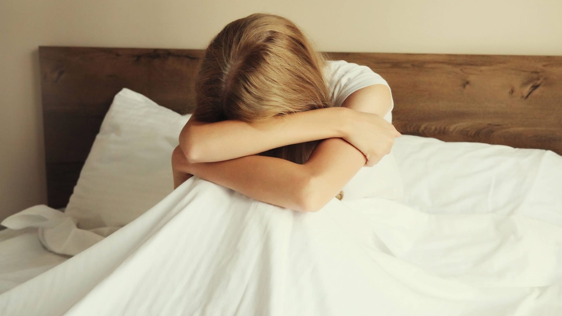 Eine aufgewühlte, weinende Frau sitzt im Bett (Symbolbild): Das Mietrecht macht es Opfern häuslicher Gewalt oft schwer, sich von den Tätern zu trennen. Eine aufgewühlte, weinende Frau sitzt im Bett (Symbolbild): Das Mietrecht macht es Opfern häuslicher Gewalt oft schwer, sich von den Tätern zu trennen.