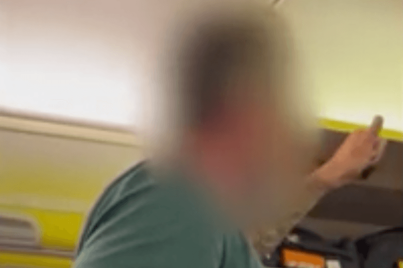 Ein Mann beleidigt Menschen im Flugzeug.