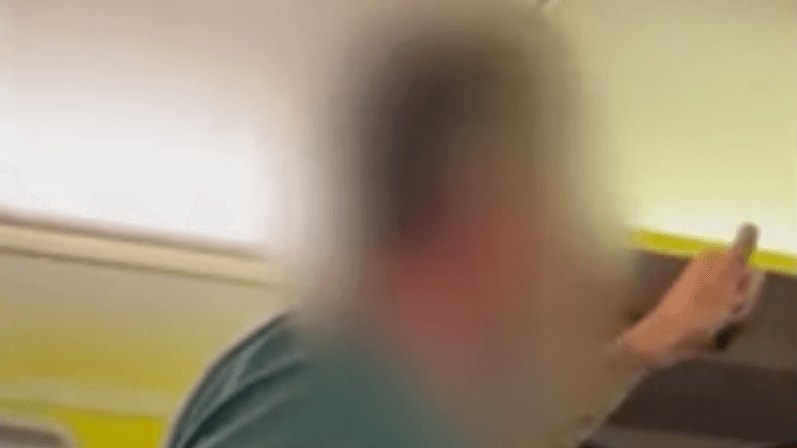 Ein Mann beleidigt Menschen im Flugzeug.