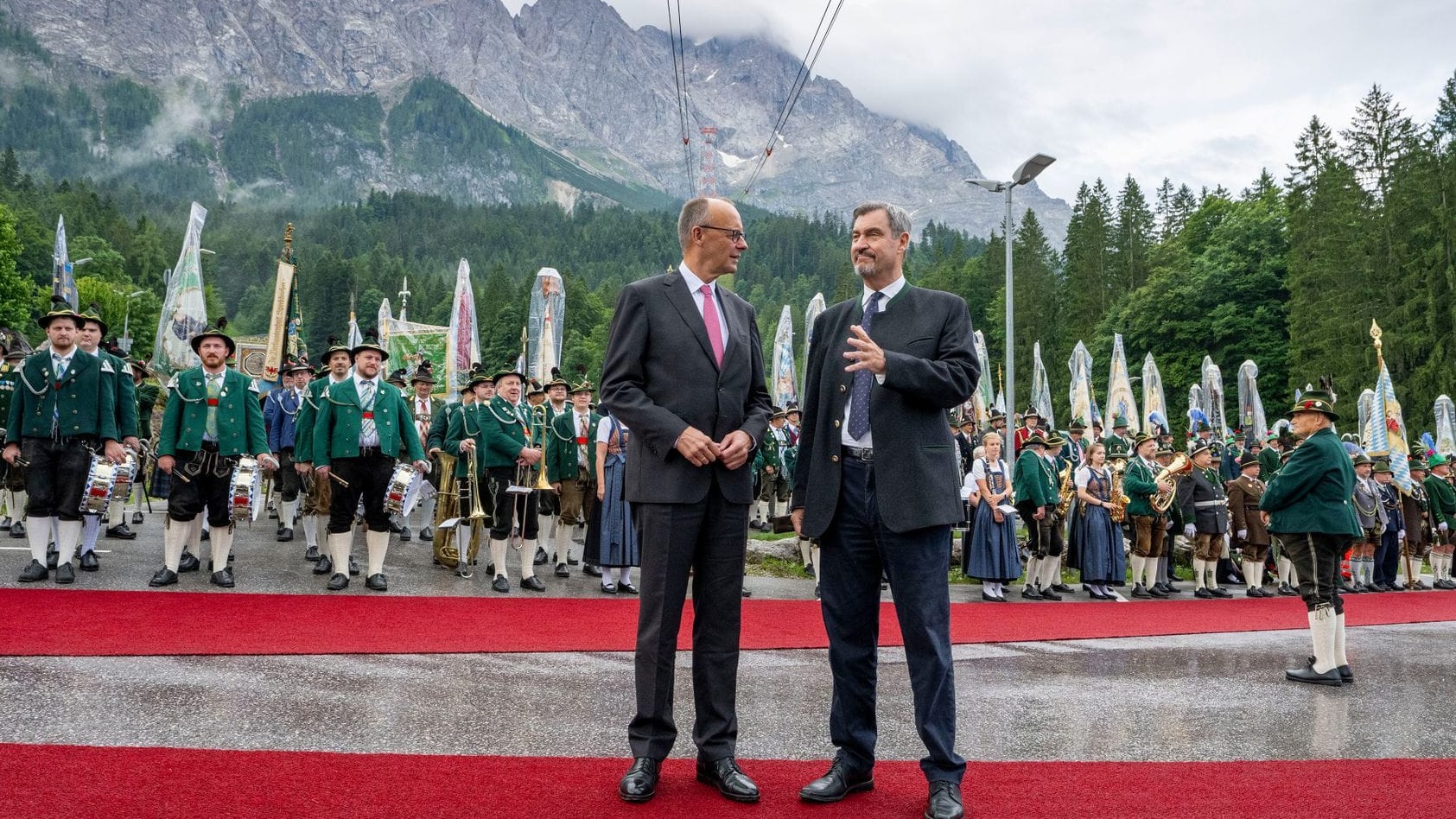 Markus Söder (CSU), Ministerpräsident von Bayern, empfängt Bundeskanzler Friedrich Merz (CDU) am Fuß der Zugspitze mit einer Abordnung von Gebirgsschützen.
