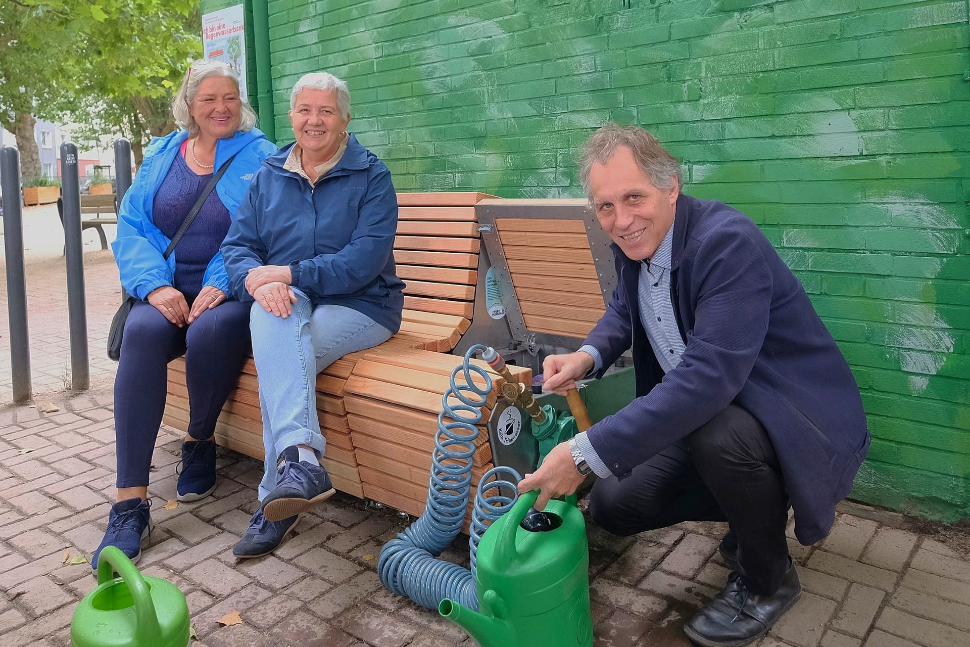 Regenwasser unter der Sitzfläche: Jochen Kral, Dezernent für Mobilität und Umwelt, weiht die neue Bank in Flingern ein.