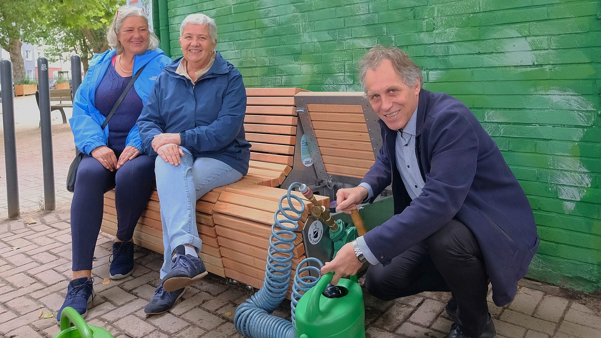 Regenwasser unter der Sitzfläche: Jochen Kral, Dezernent für Mobilität und Umwelt, weiht die neue Bank in Flingern ein.